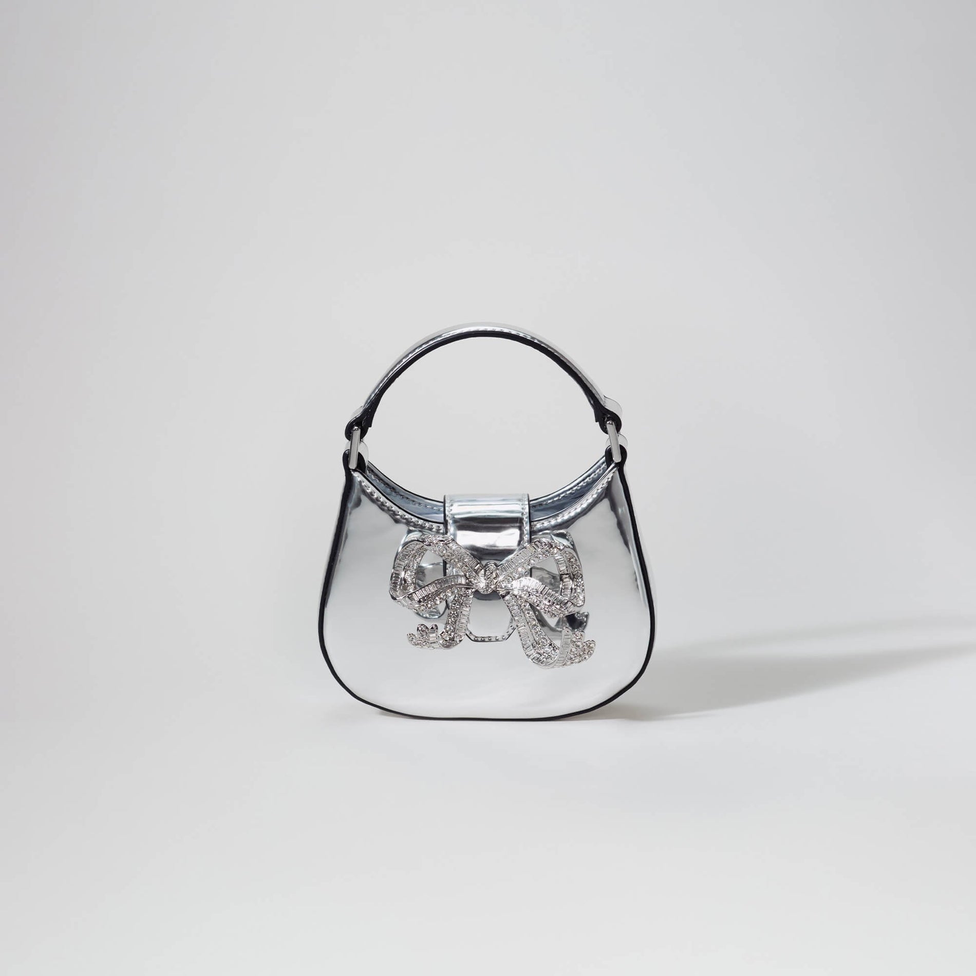 A woman wearing the Silver Crescent Bow Micro Bag