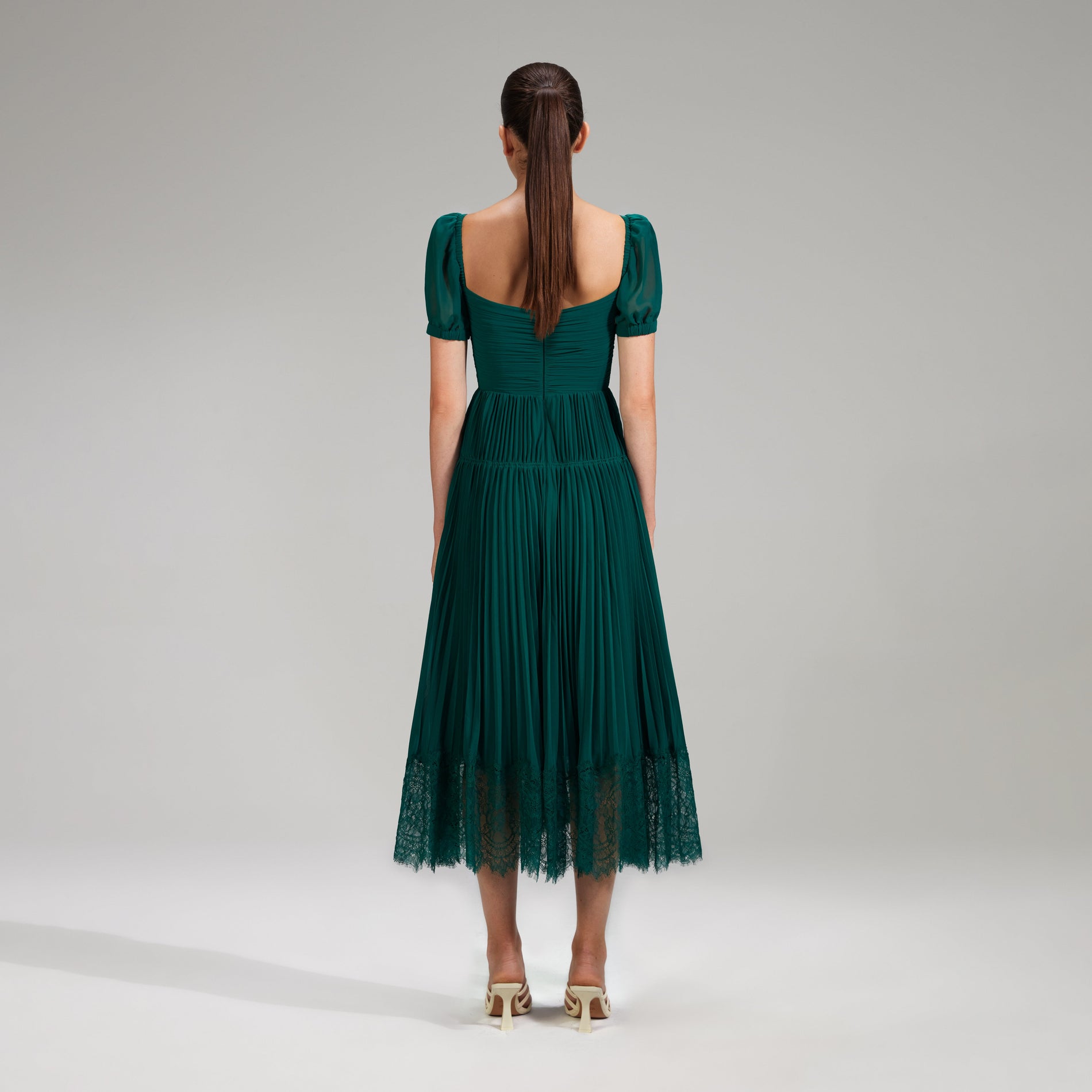 A woman wearing the Deep Green Chiffon Midi Dress