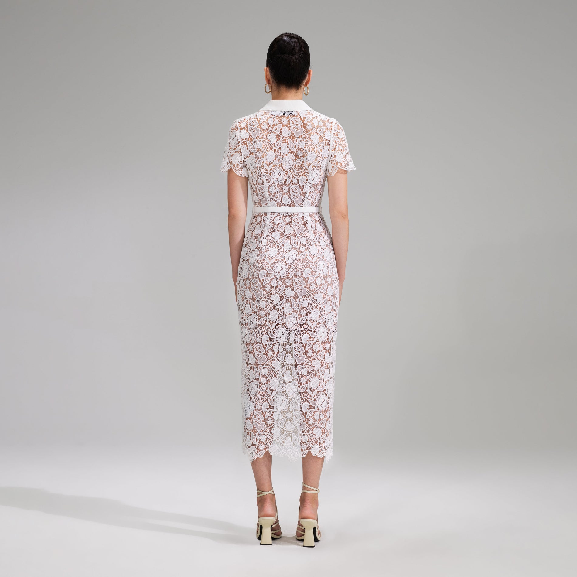 A woman wearing the White Magnolia Lace Midi Dress