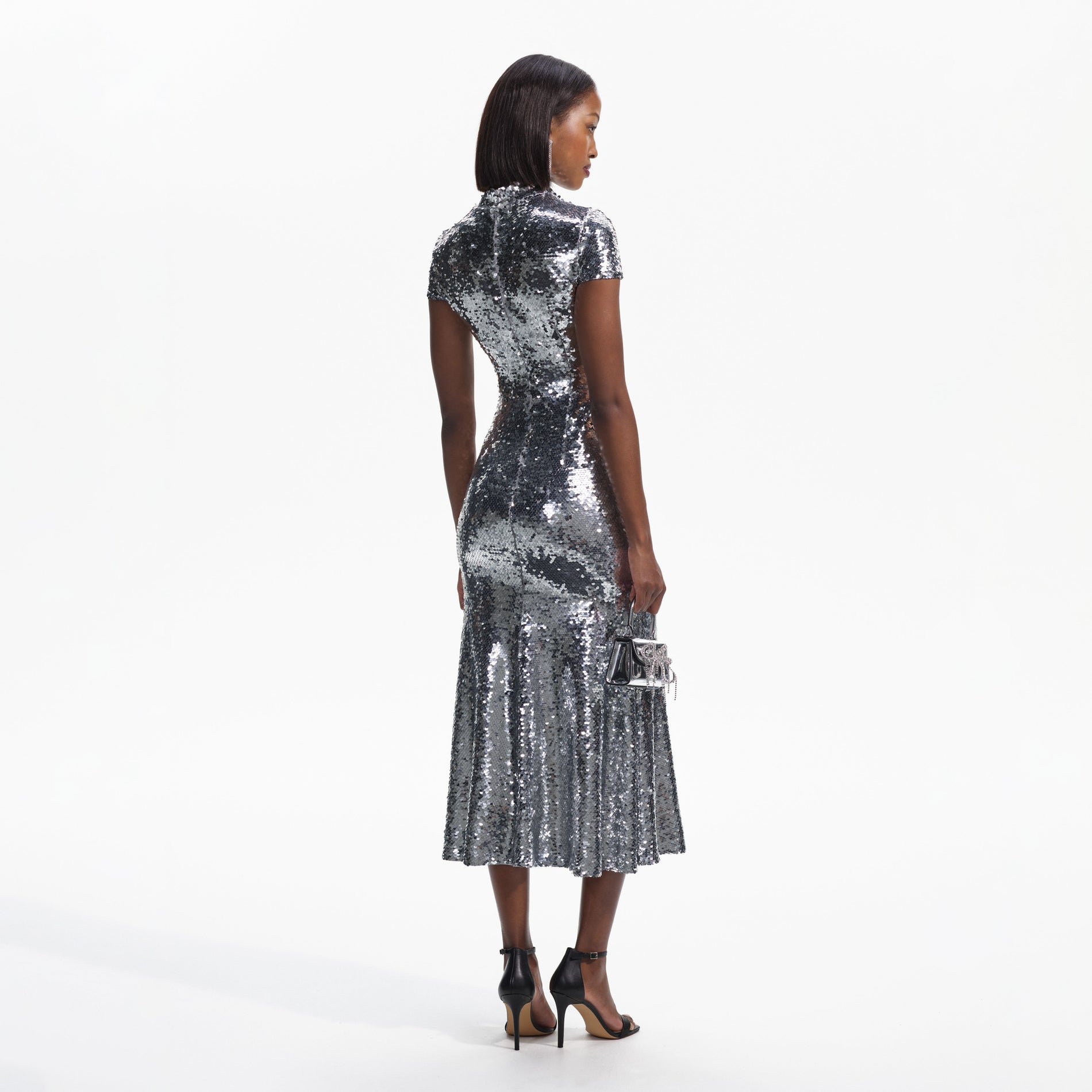 Back view of a woman wearing the Silver Sequin Twist Neck Midi Dress