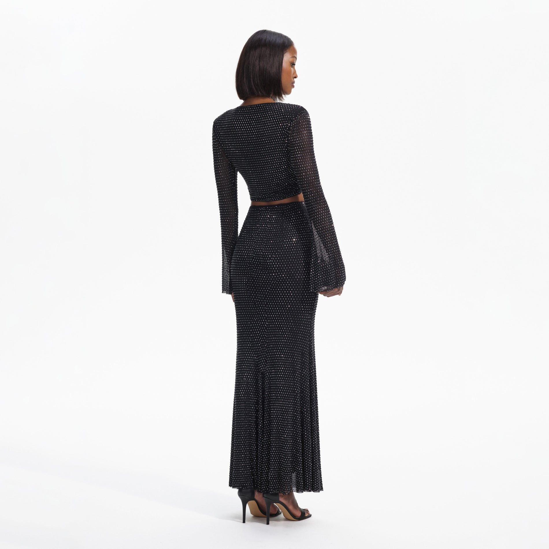 Back view of a woman wearing the Black Rhinestone  Maxi Skirt