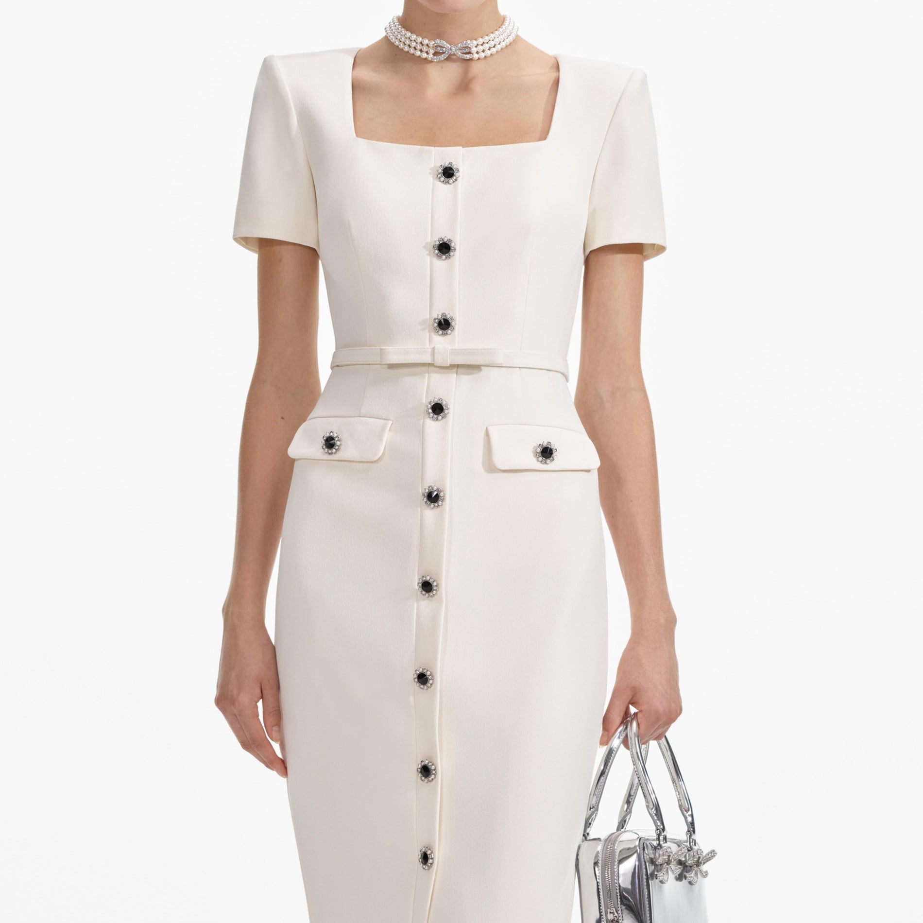 A close up of a woman wearing the Cream Crepe Button Midi Dress