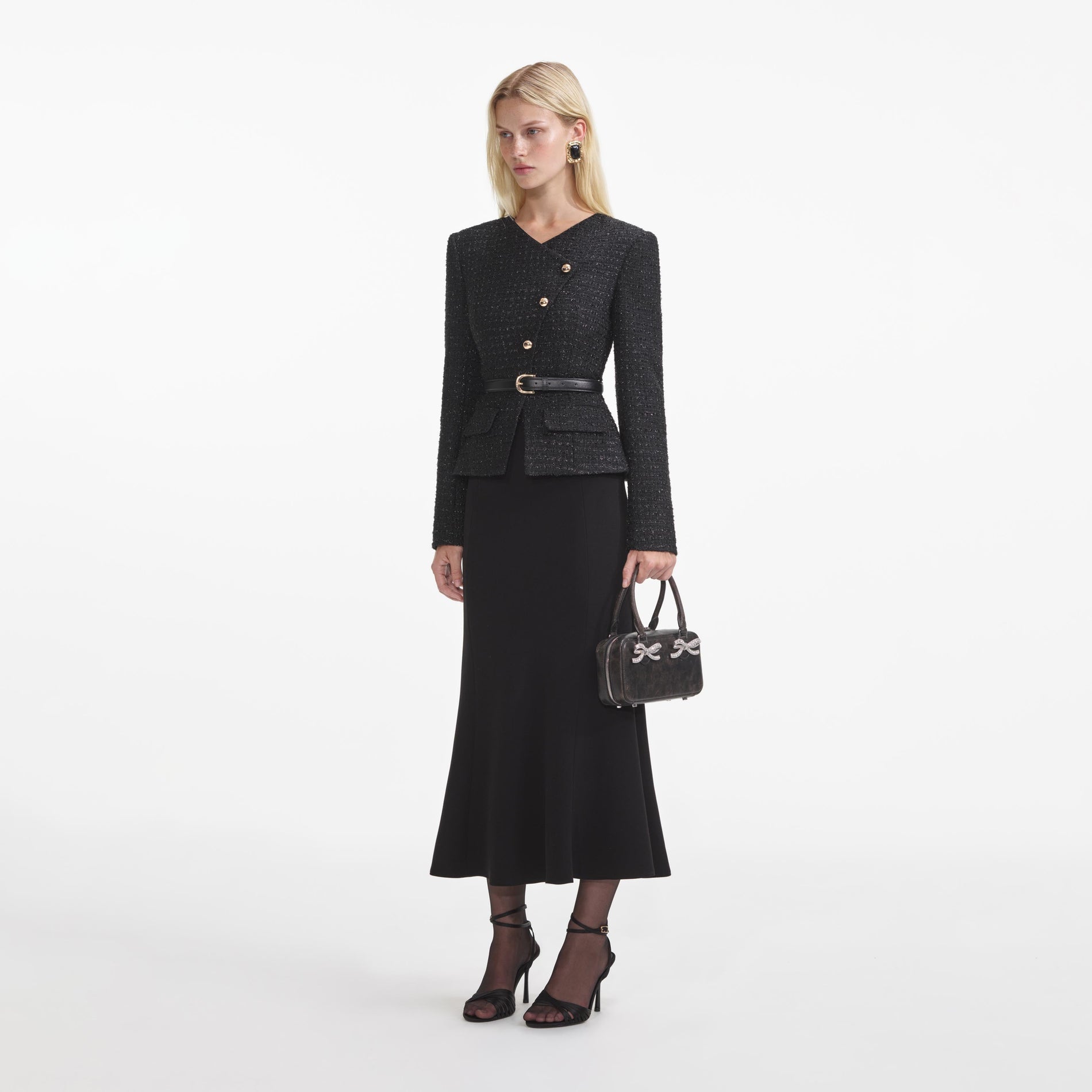 Side view of a woman wearing the Black Boucle Asymmetric Midi Dress