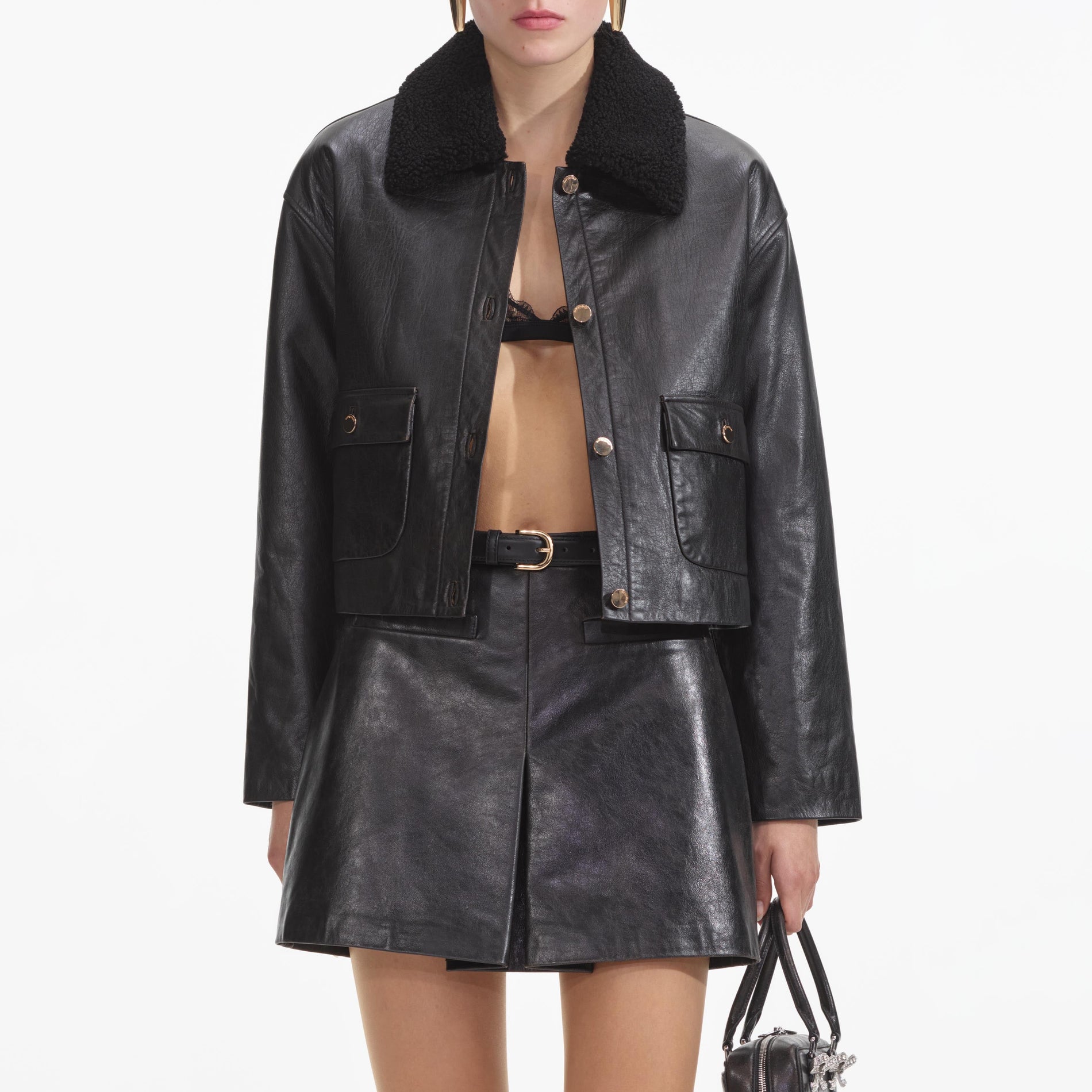 A close up of a woman wearing the Black Leather Shearling Jacket