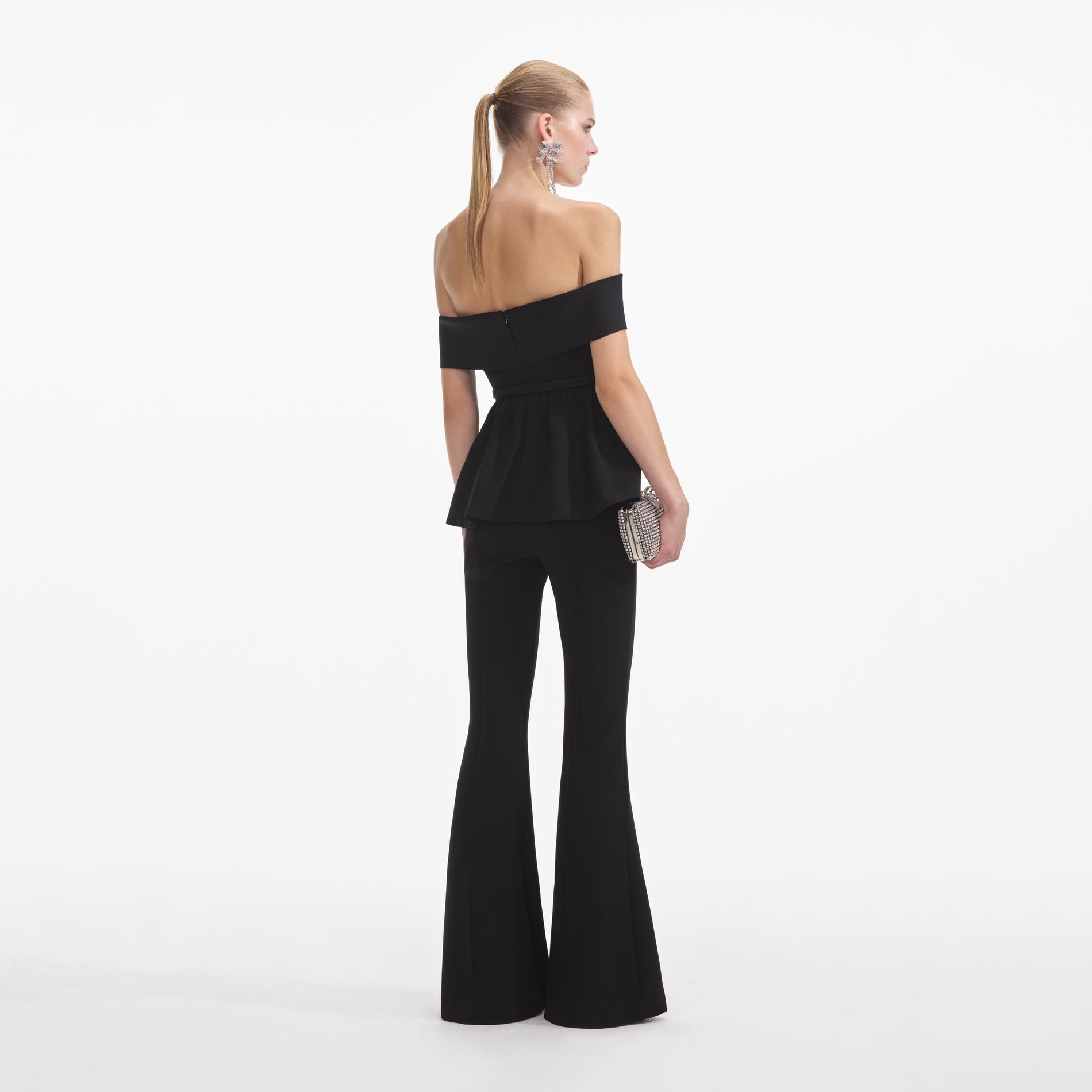 Back view of a woman wearing the Black Crepe Off Shoulder Jumpsuit