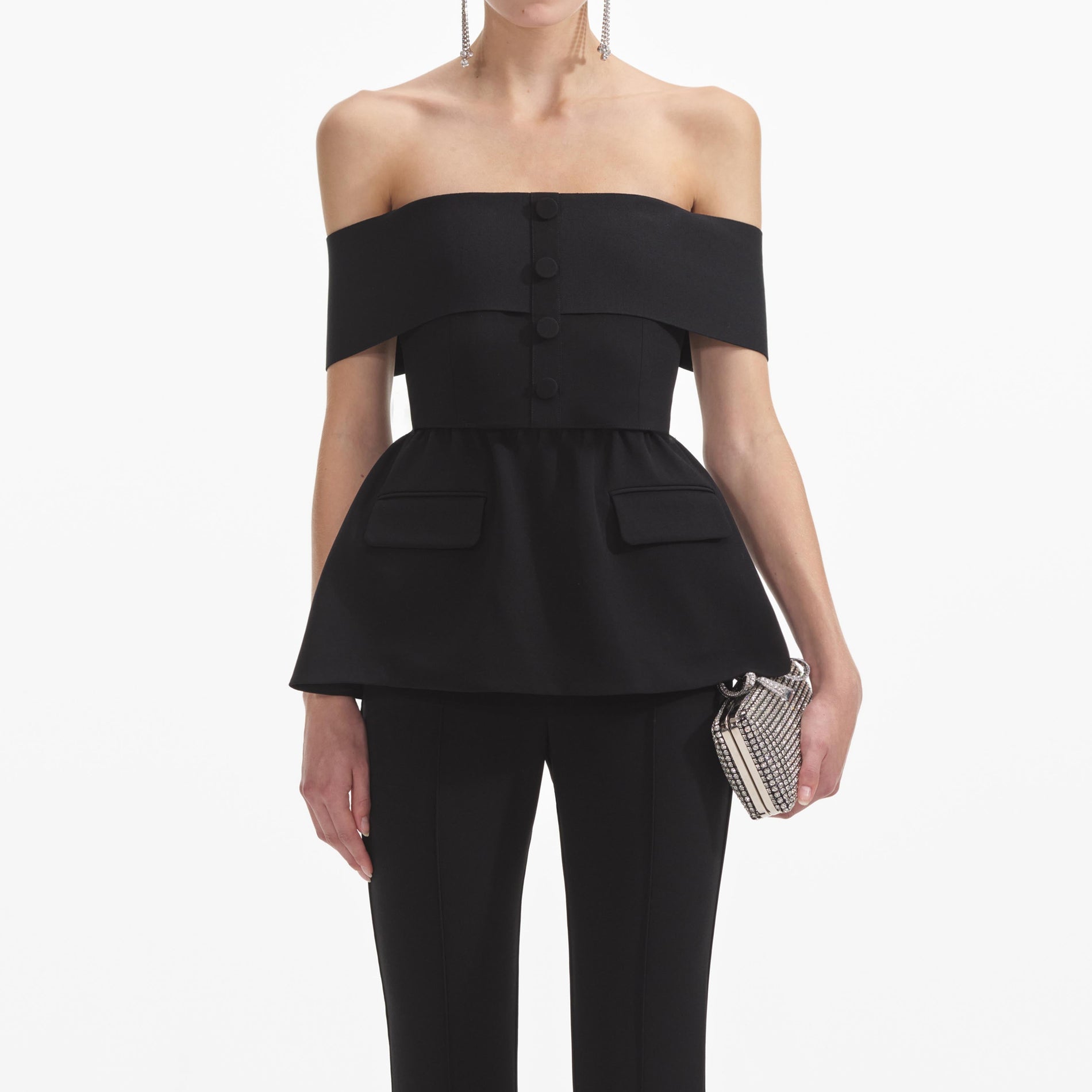 A close up of a woman wearing the Black Crepe Off Shoulder Jumpsuit