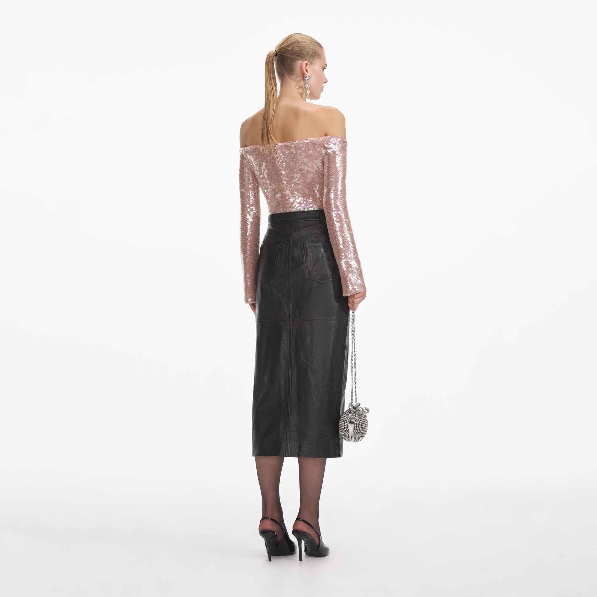 Back view of a woman wearing the Black Leather Midi Skirt