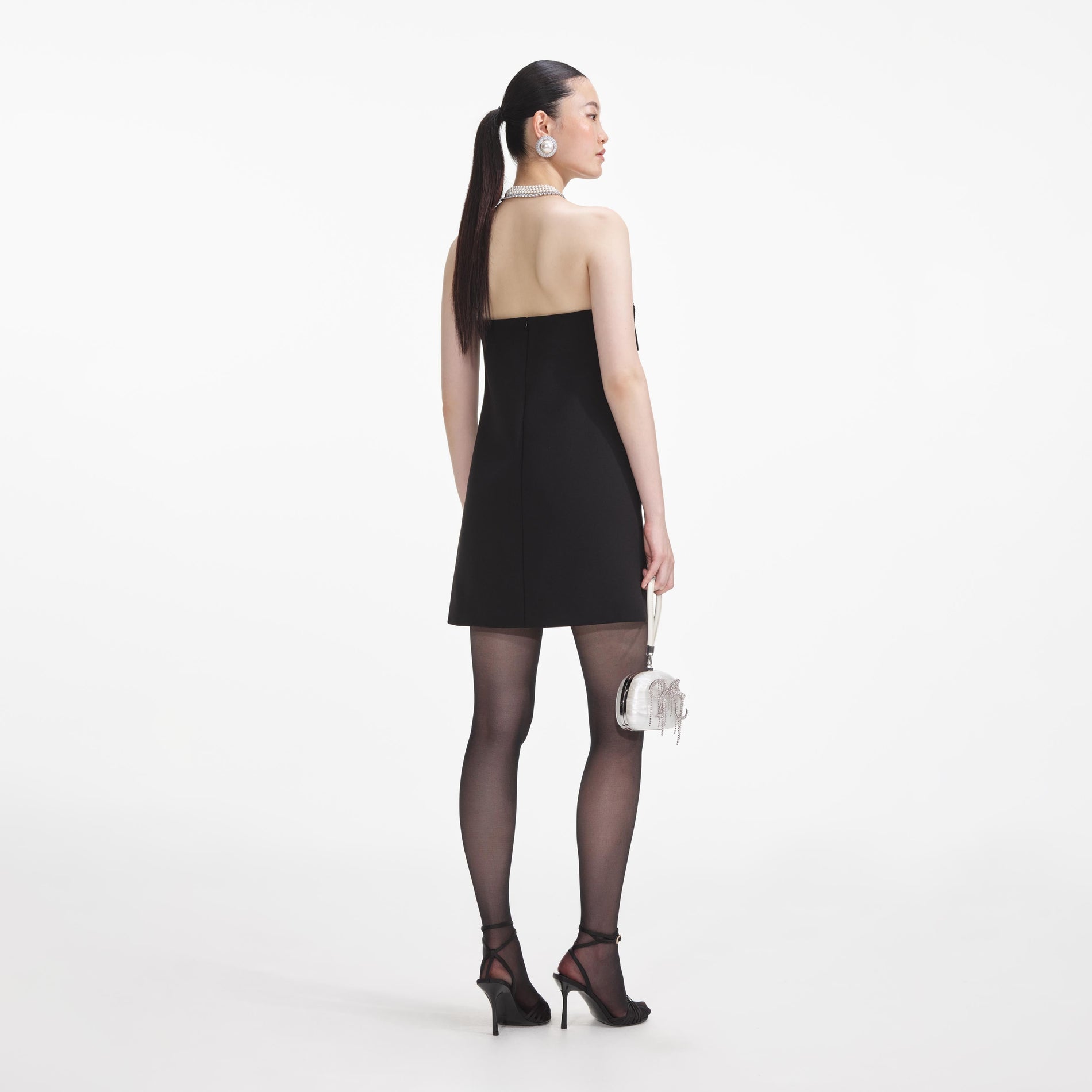 Back view of a woman wearing the Black Crepe Bandeau Mini Dress