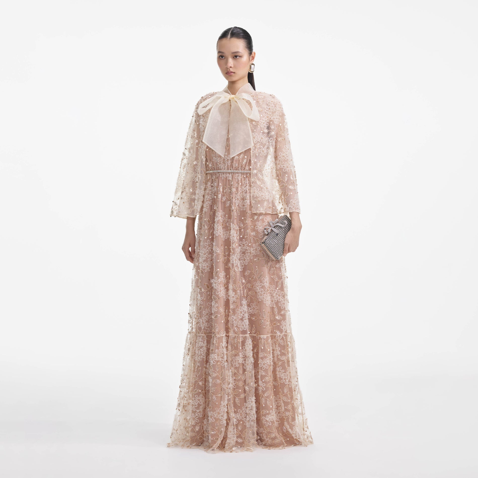 Side view of a woman wearing the Embellished Cape Maxi Dress