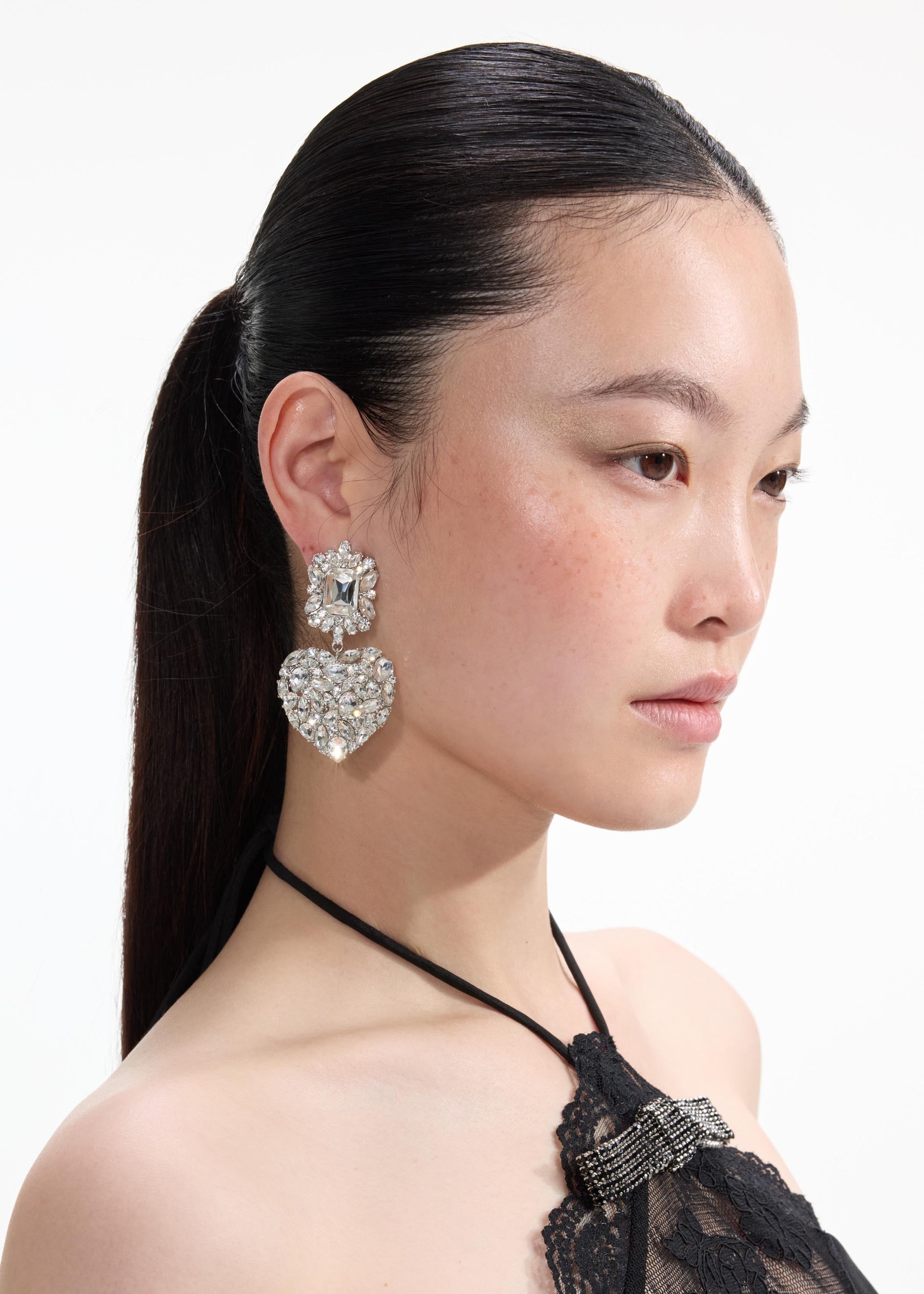 Back view of a woman wearing the Crystal Heart Tiered Earrings