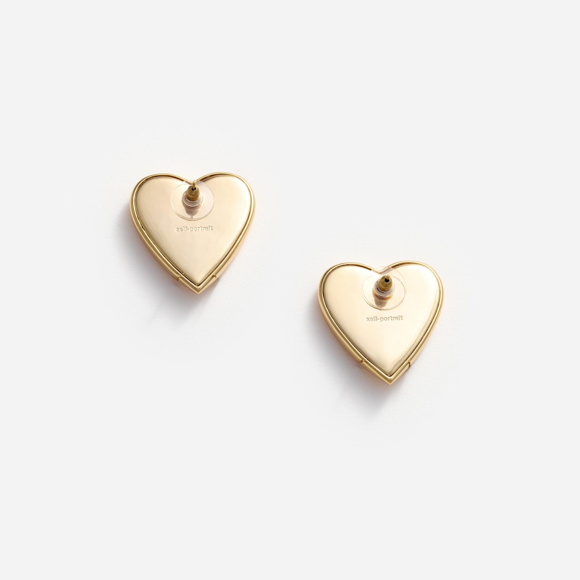 Side view of a woman wearing the Gold Heart Ridged Earrings