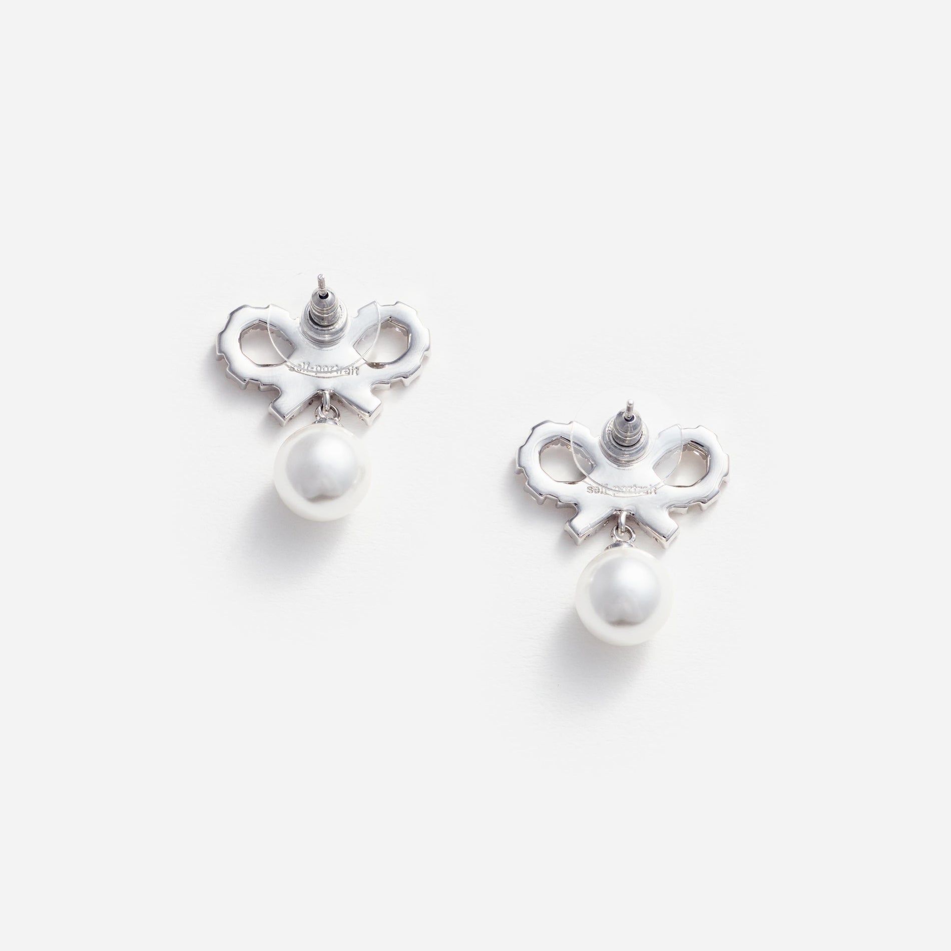 Side view of a woman wearing the Micro Bow Pearl Earrings