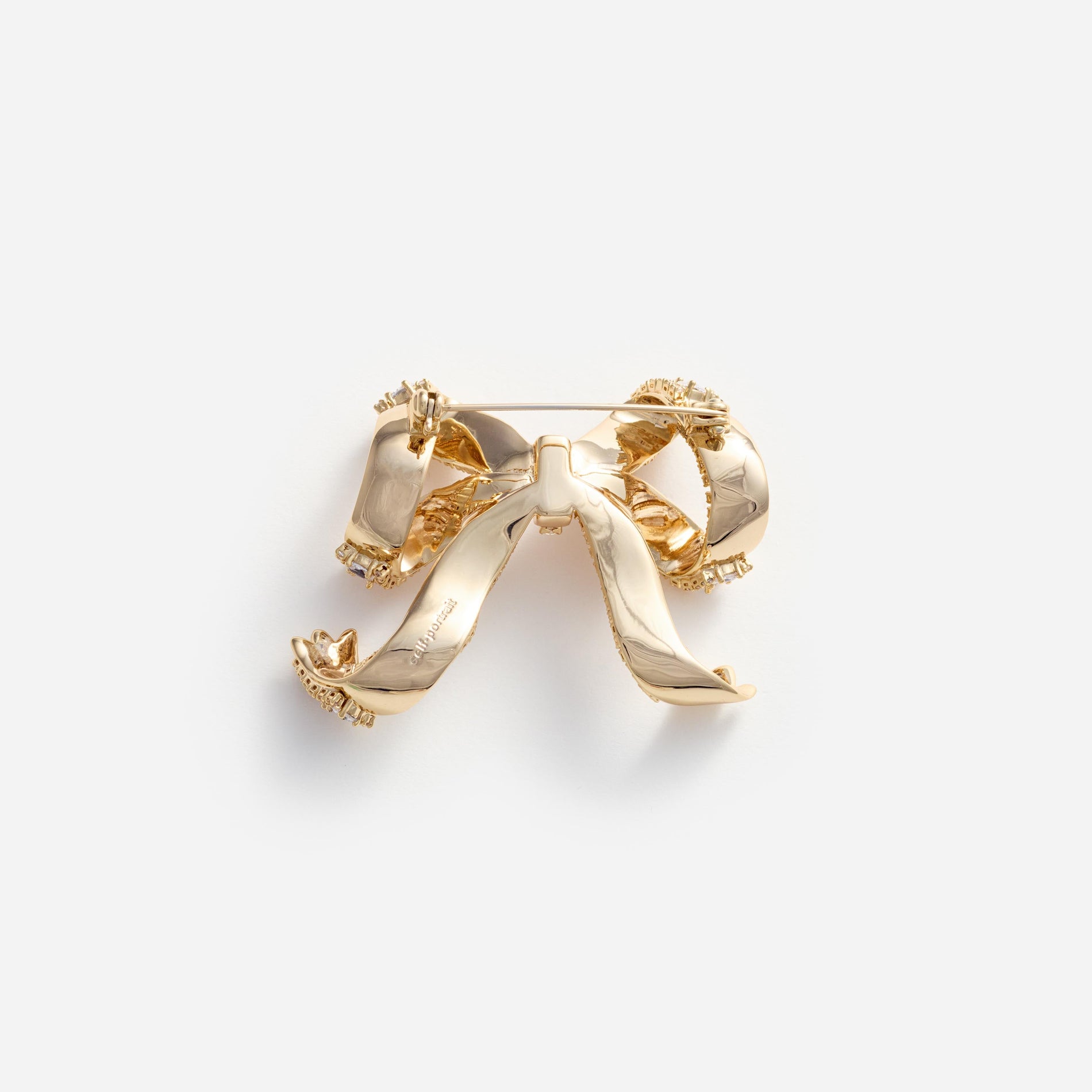 Side view of a woman wearing the Gold Crystal Bow Brooch