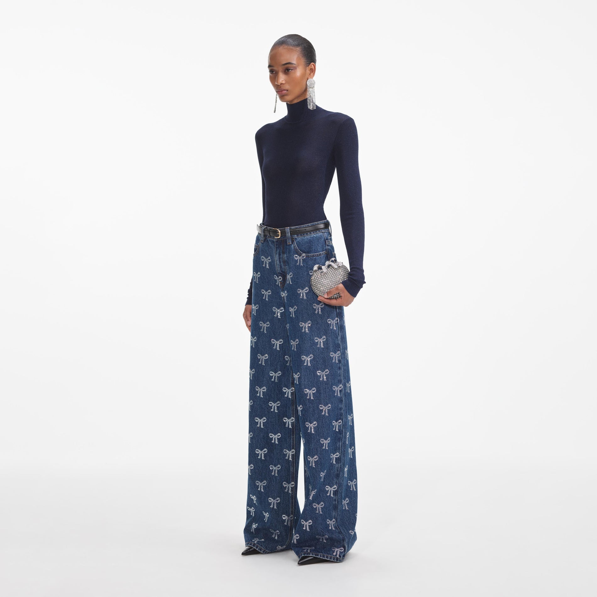Side view of a woman wearing the Rhinestone Bow Denim Jeans