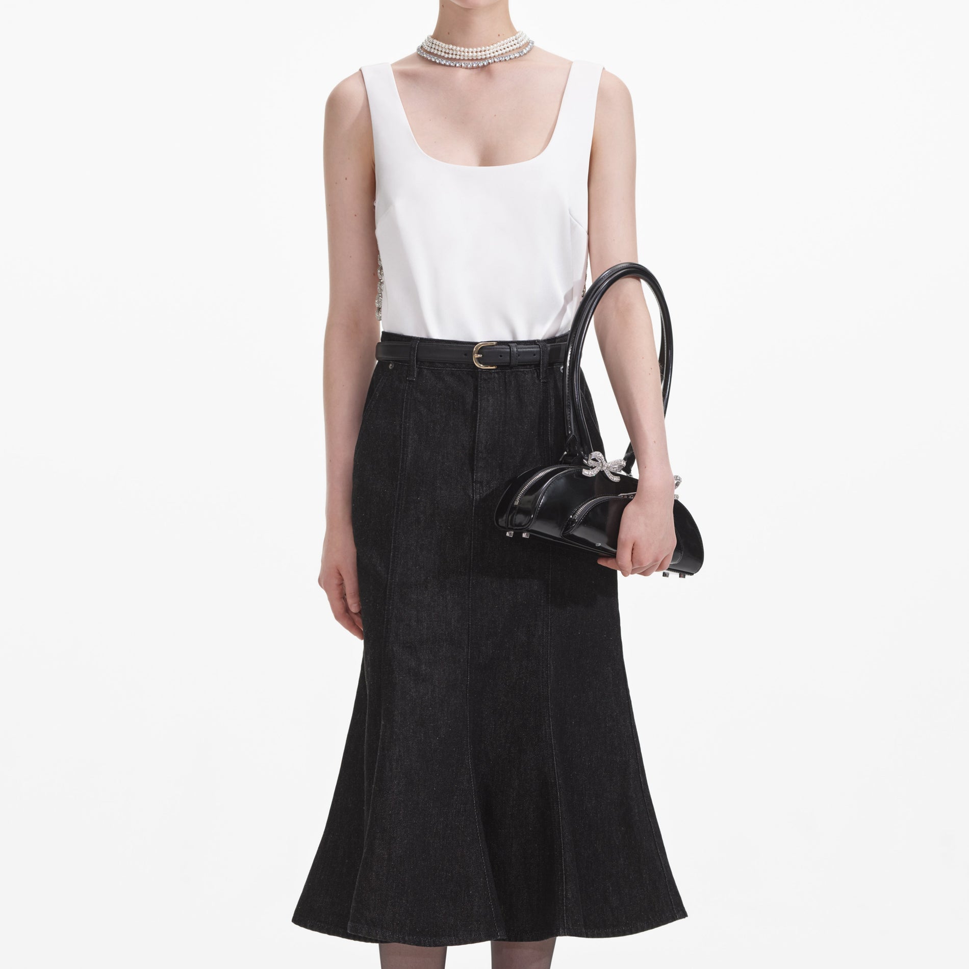 A close up of a woman wearing the Black Flared Denim Midi Skirt