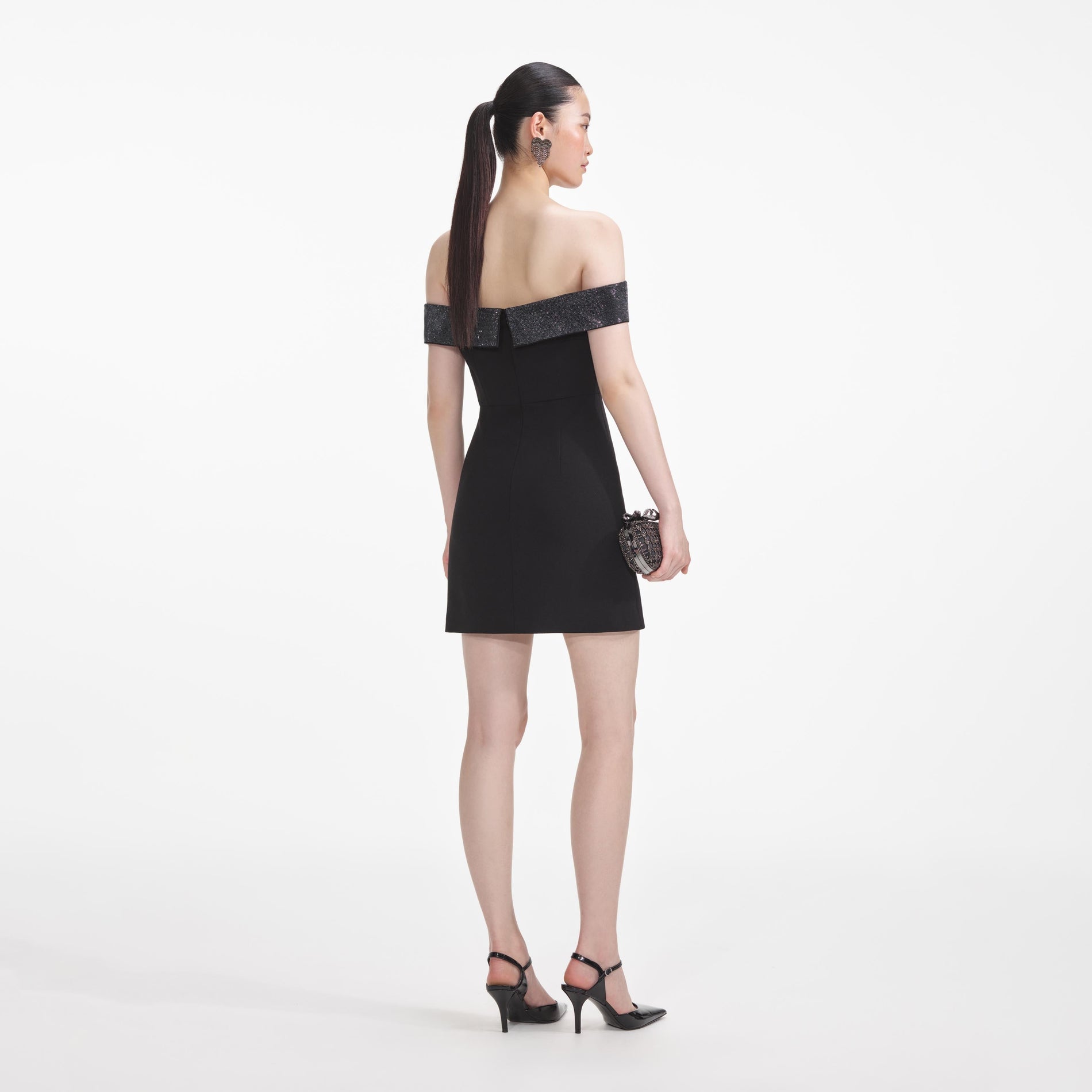 Back view of a woman wearing the Black Crepe Bow Mini Dress