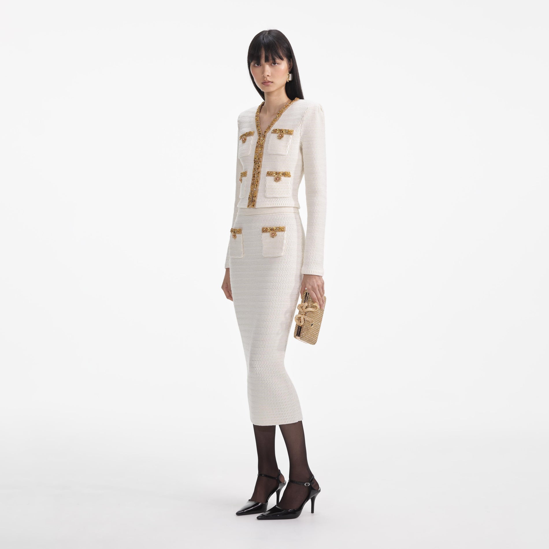 Side view of a woman wearing the Cream Lurex Knit Midi Skirt
