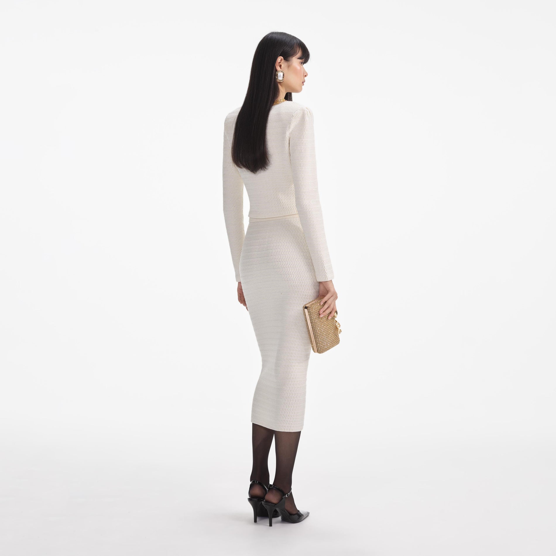 Back view of a woman wearing the Cream Lurex Knit Midi Skirt