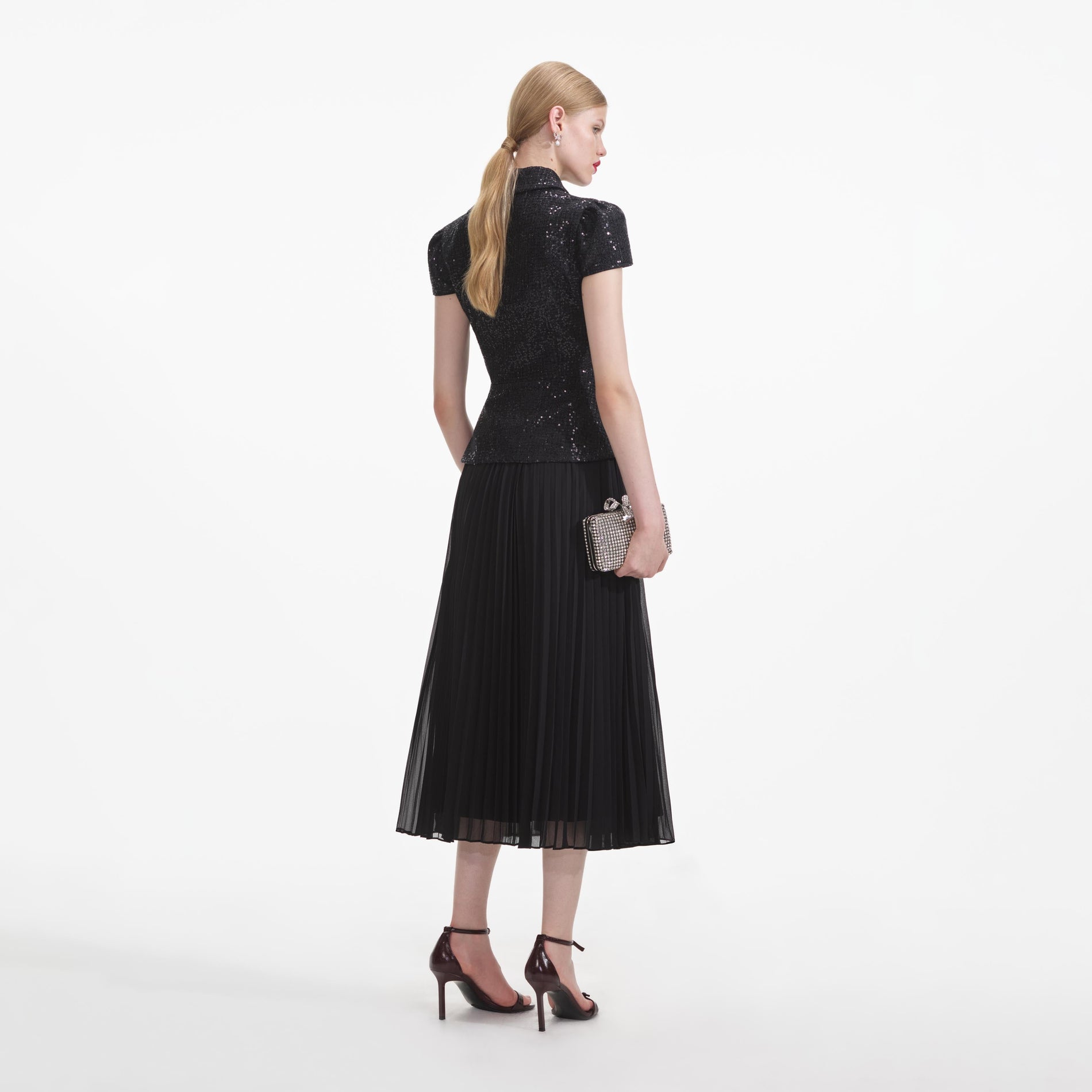 Back view of a woman wearing the Black Boucle Bow Midi Dress