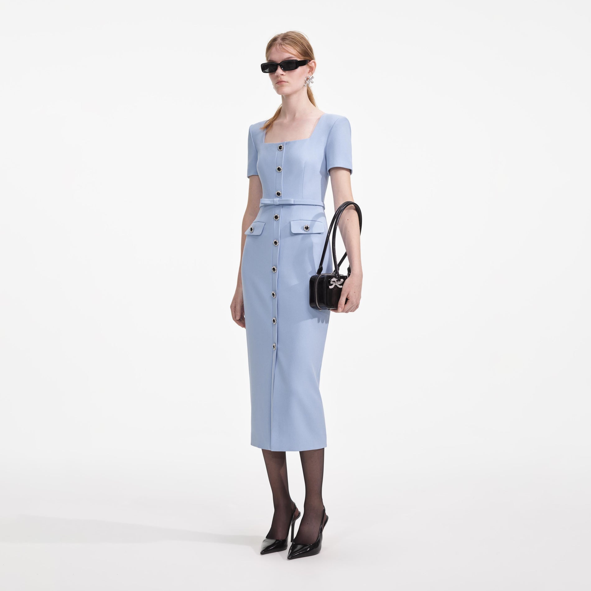 Side view of a woman wearing the Blue Crepe Button Midi Dress