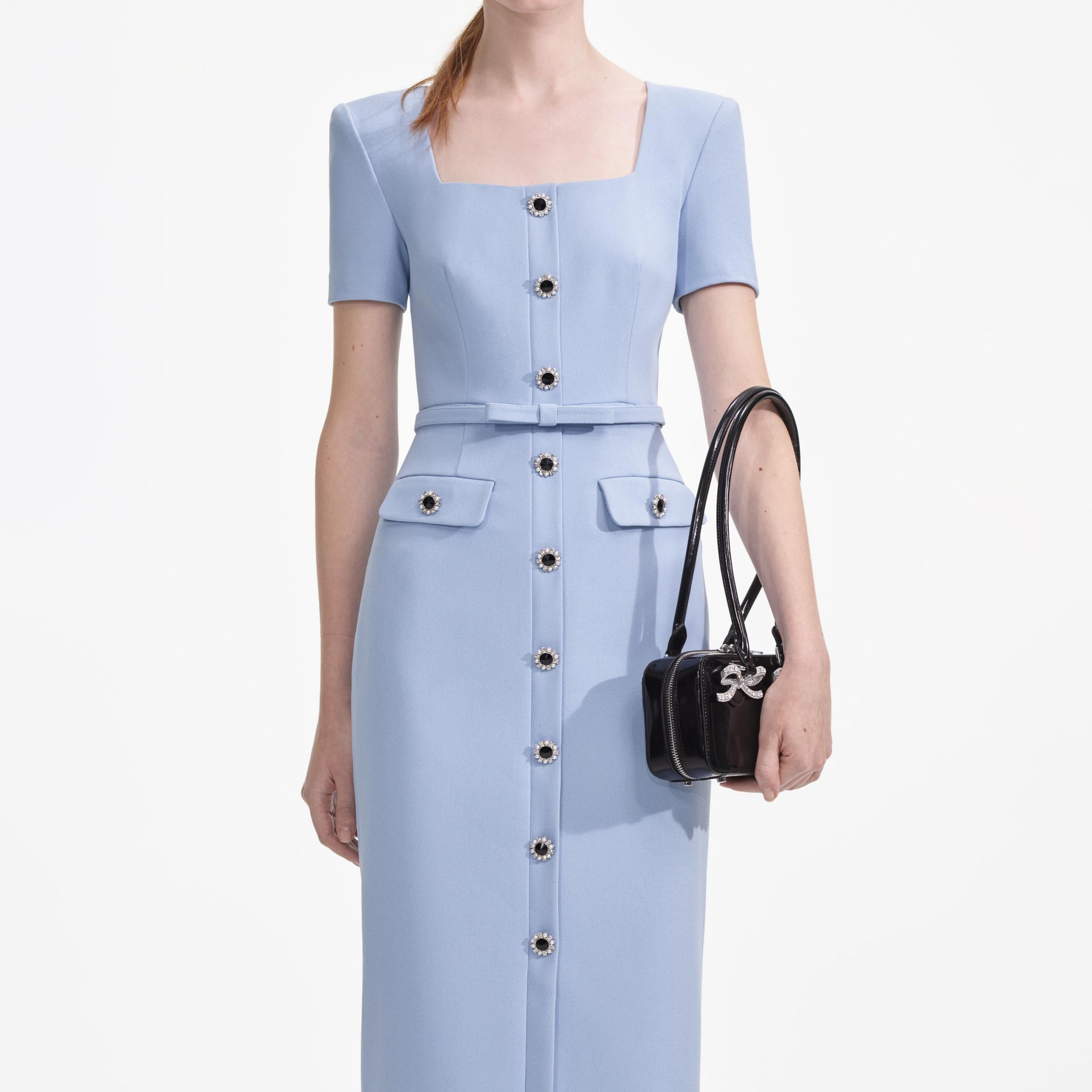 A close up of a woman wearing the Blue Crepe Button Midi Dress