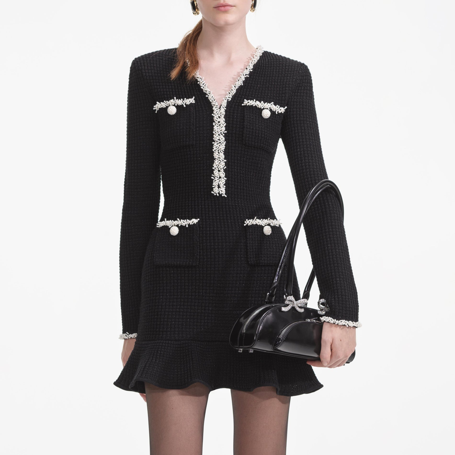 A close up of a woman wearing the Black Pearl Trim Knit Mini Dress