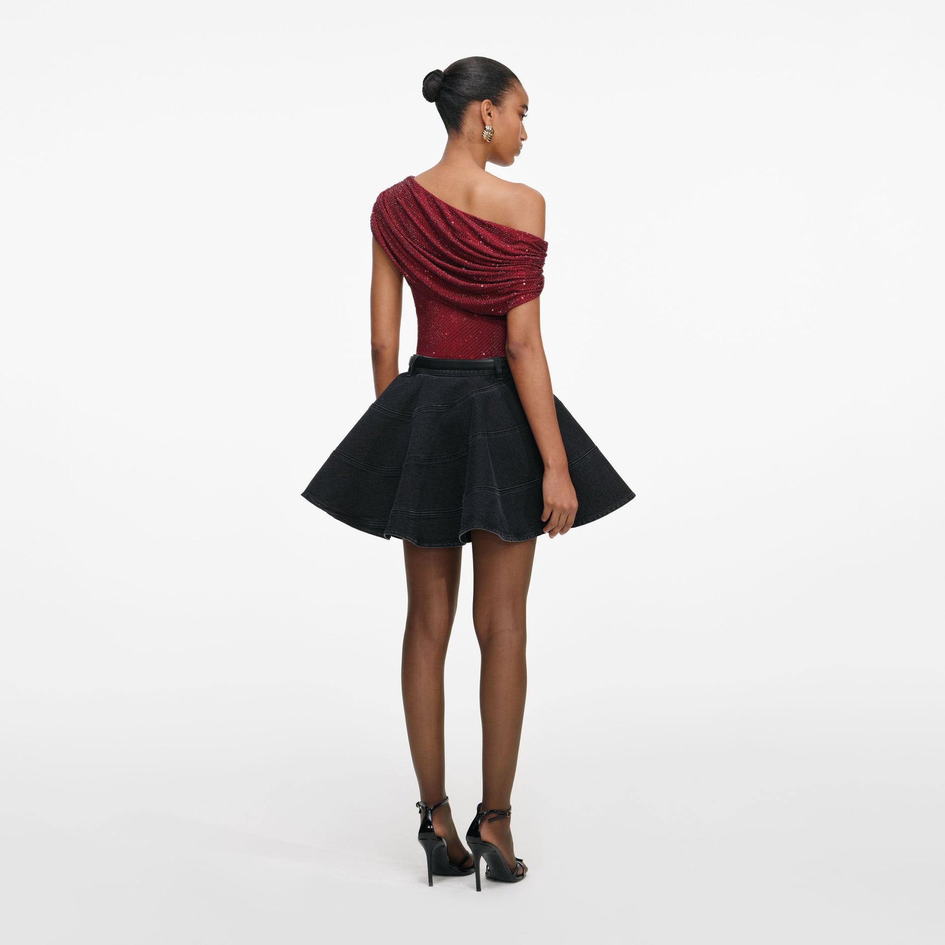 Back view of a woman wearing the Black Flared Denim Mini Skirt