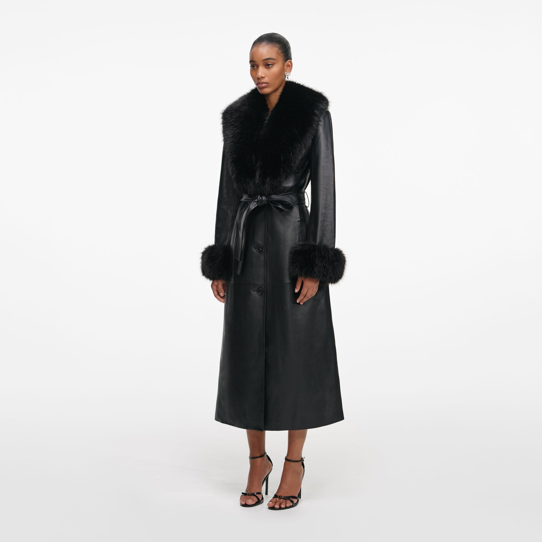 Side view of a woman wearing the Black Leather Faux Fur Collared Coat