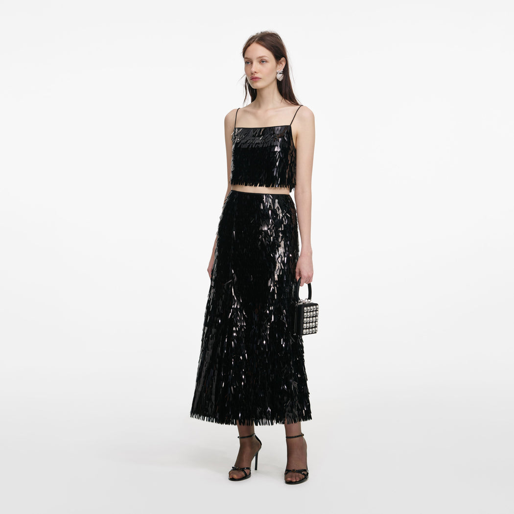 Side view of a woman wearing the Black Sequin Midi Skirt