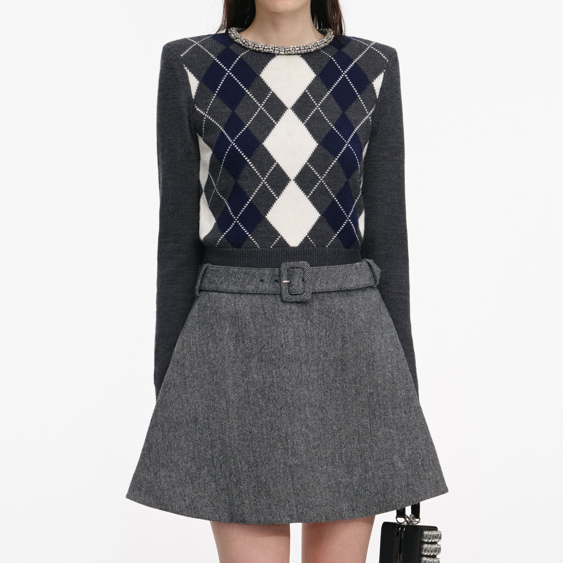 A close up of a woman wearing the Grey Argyle Crystal Trim Jumper