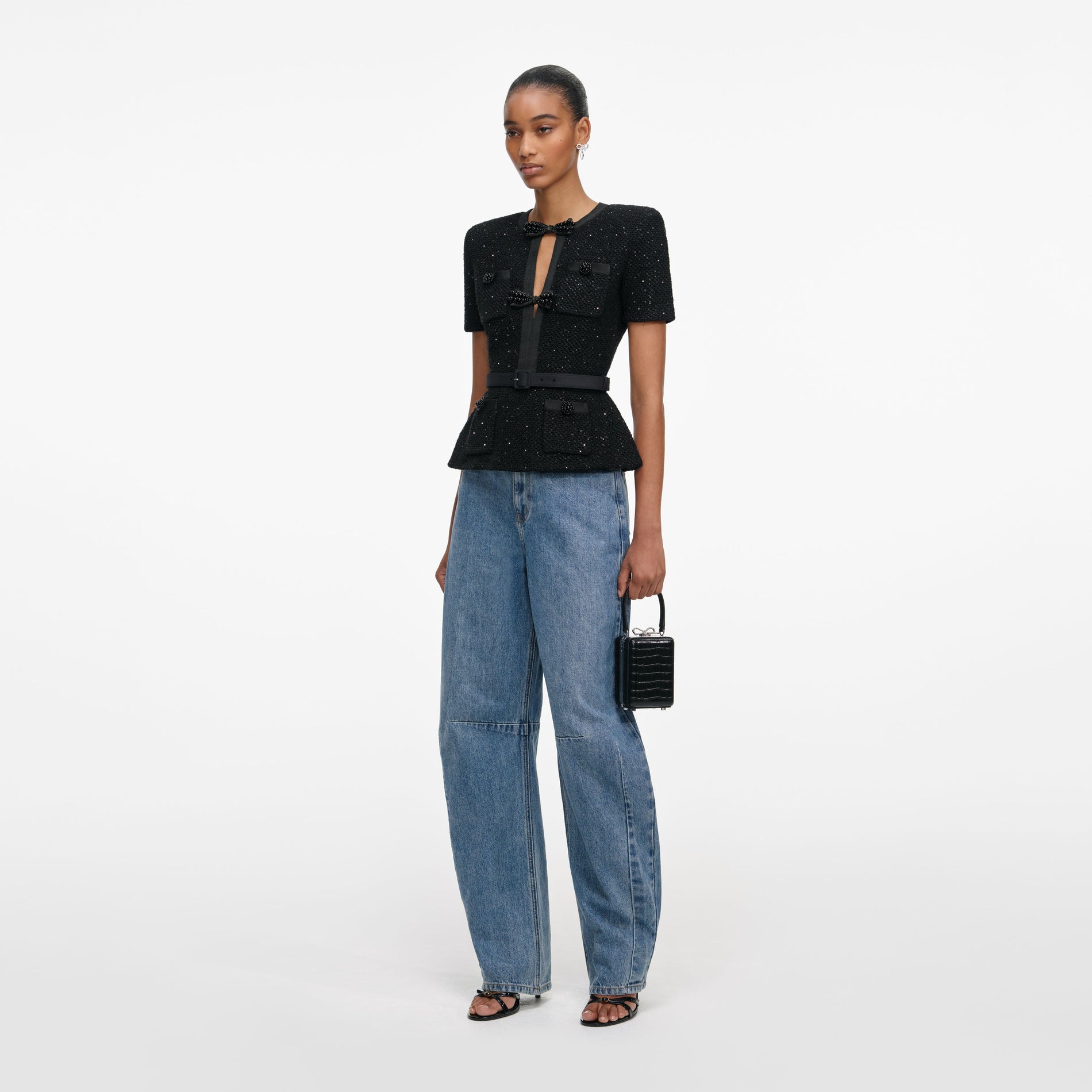 Side view of a woman wearing the Black Sequin Knit Top