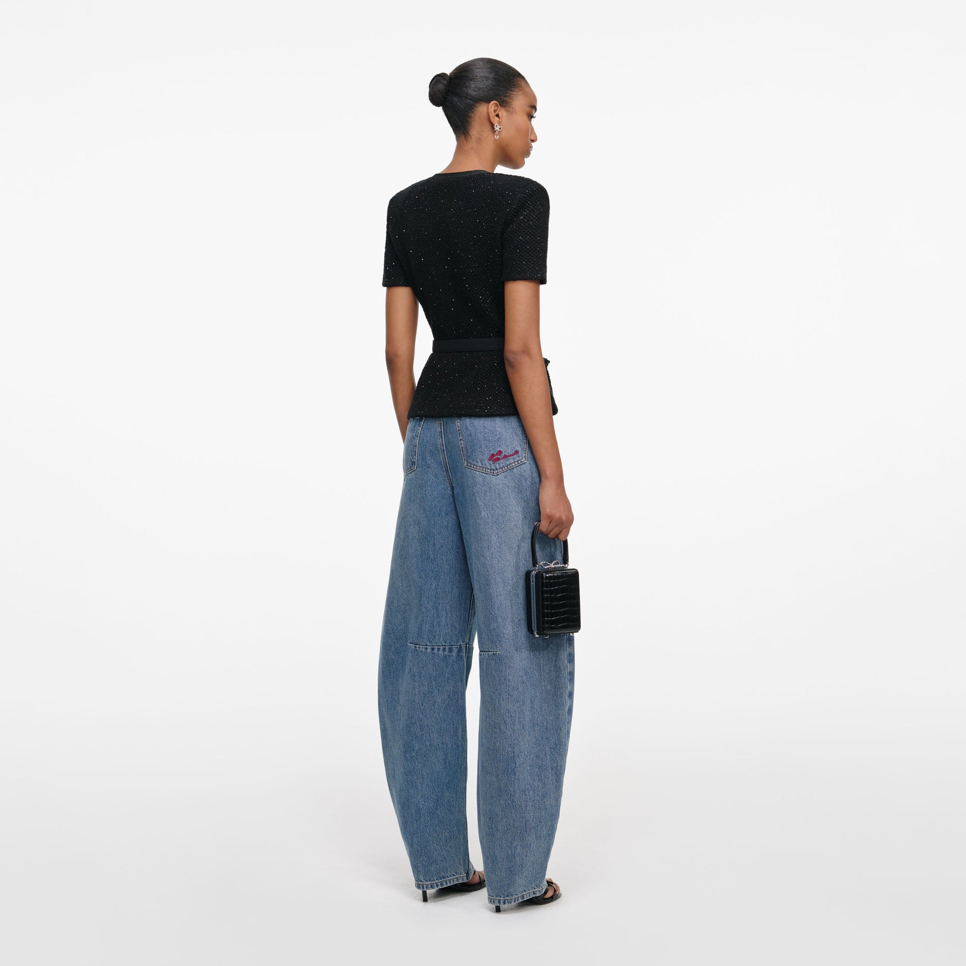 Back view of a woman wearing the Black Sequin Knit Top