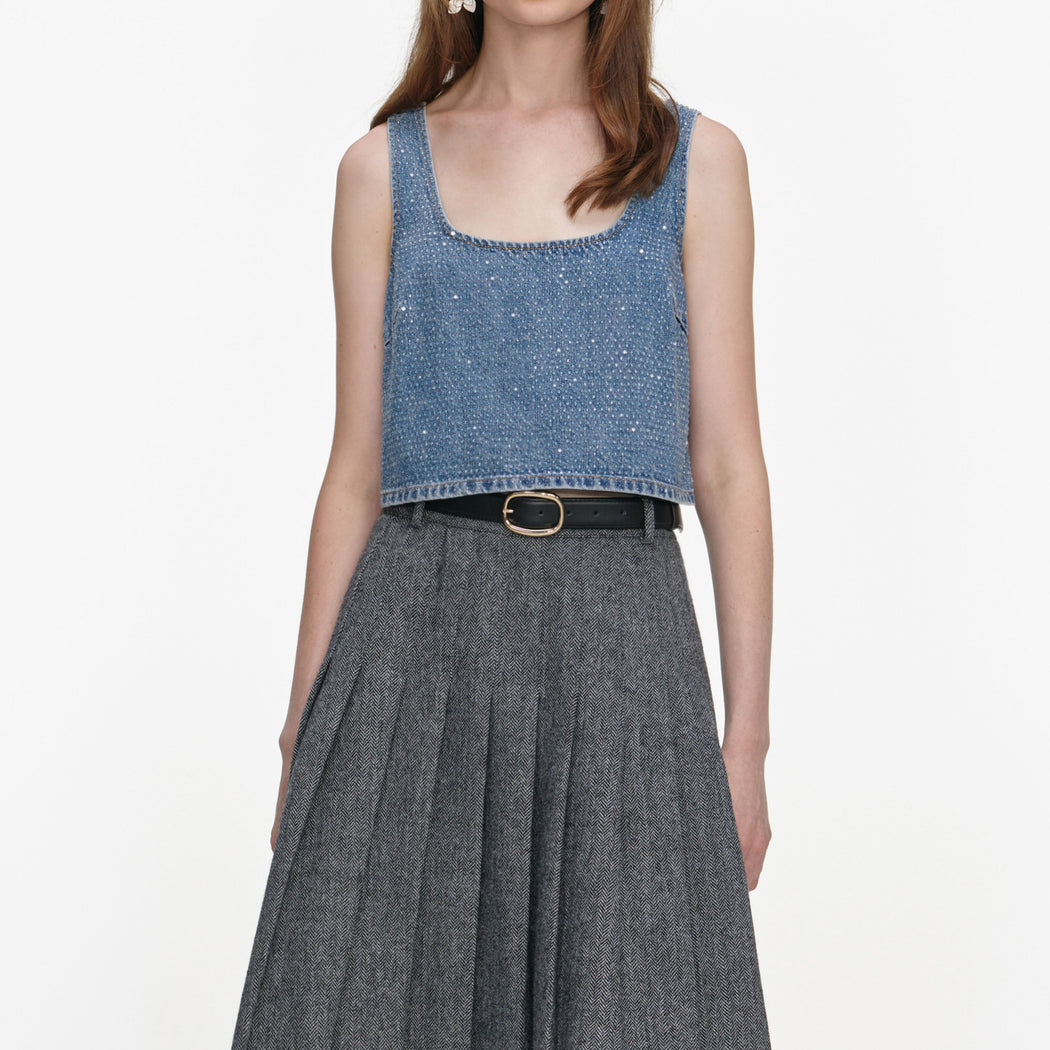 A close up of a woman wearing the Grey Herringbone Pleated Midi Skirt