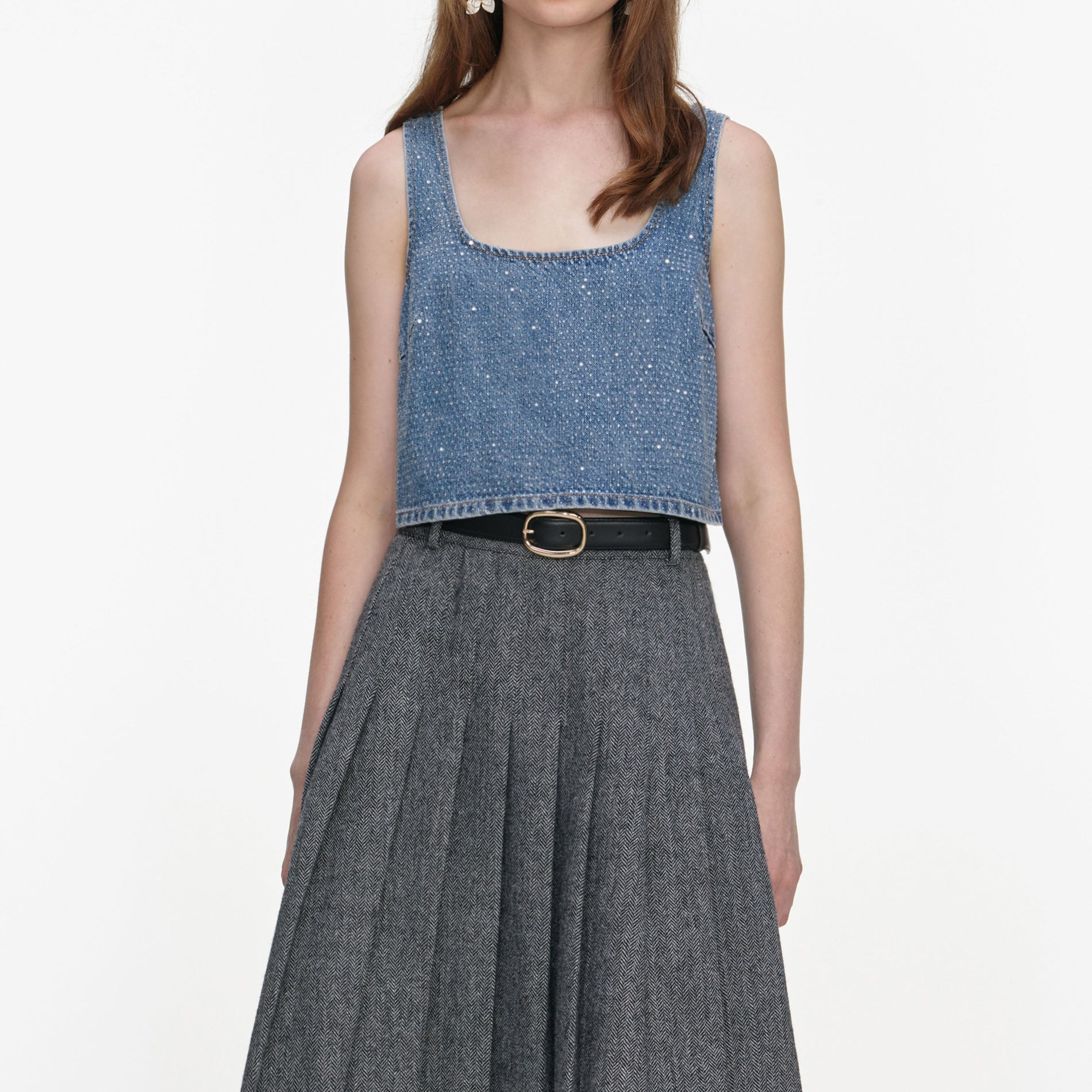A close up of a woman wearing the Grey Herringbone Pleated Midi Skirt