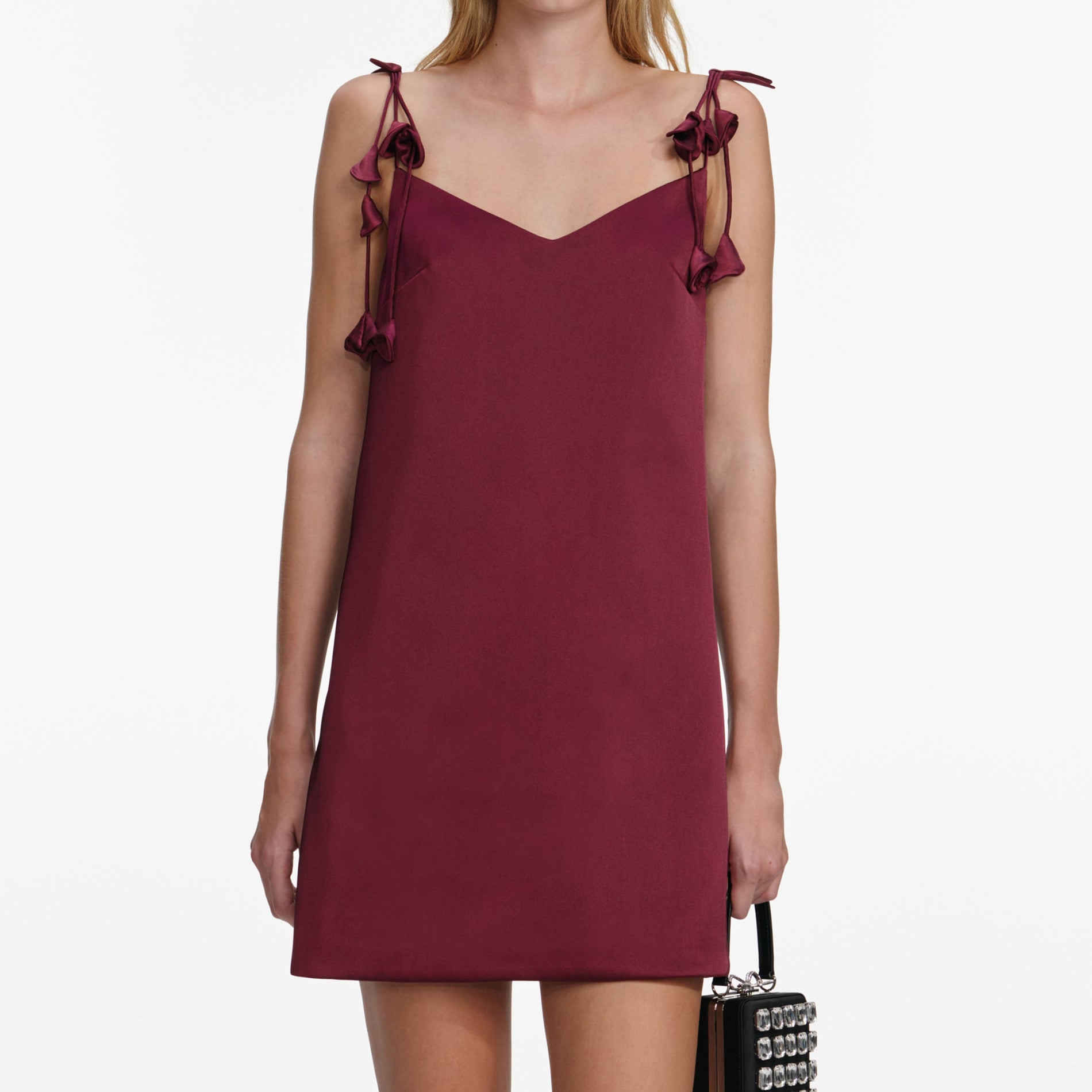 A close up of a woman wearing the Burgundy Satin Flower Mini Dress