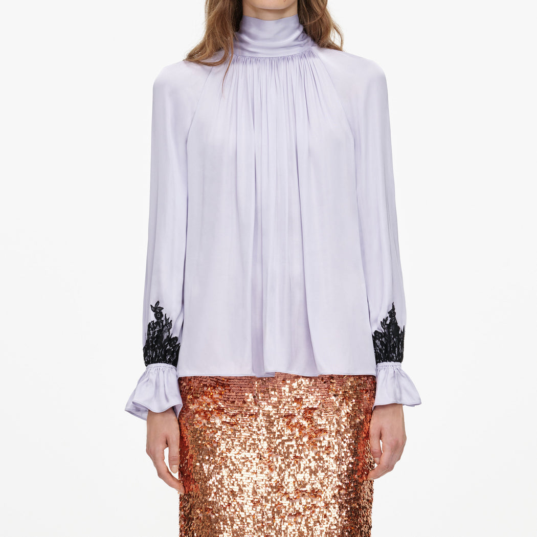 A close up of a woman wearing the Lilac Viscose Contrast Lace Blouse