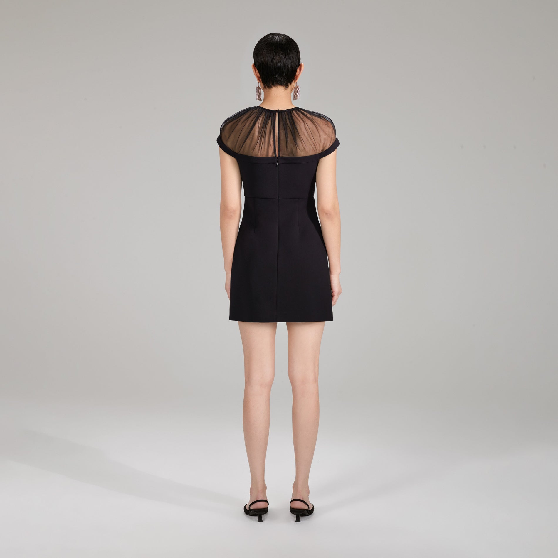 A woman wearing the Bonded Crepe Bow Mini Dress