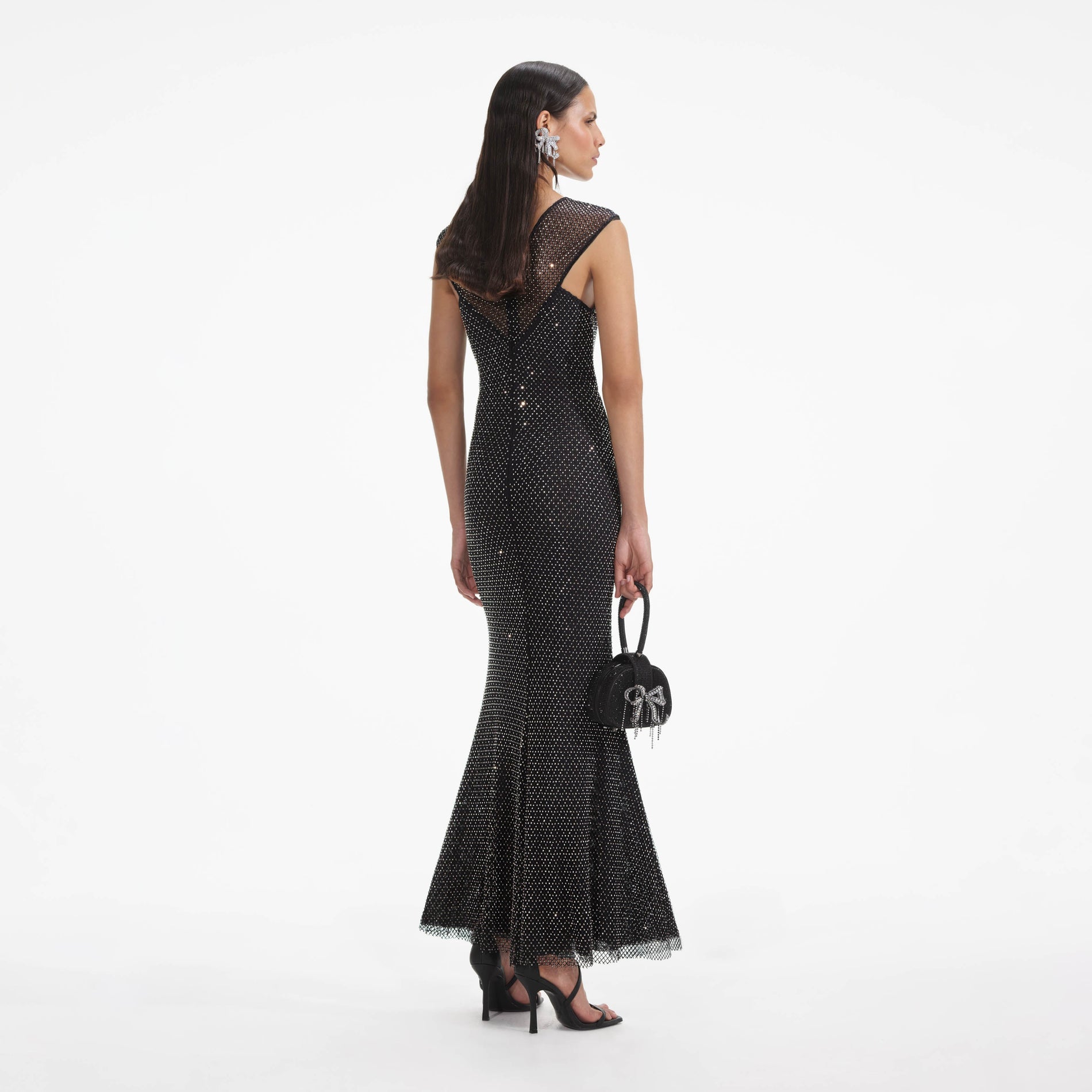 Back view of a woman wearing the Black Rhinestone Fishnet Crossover Midi Dress