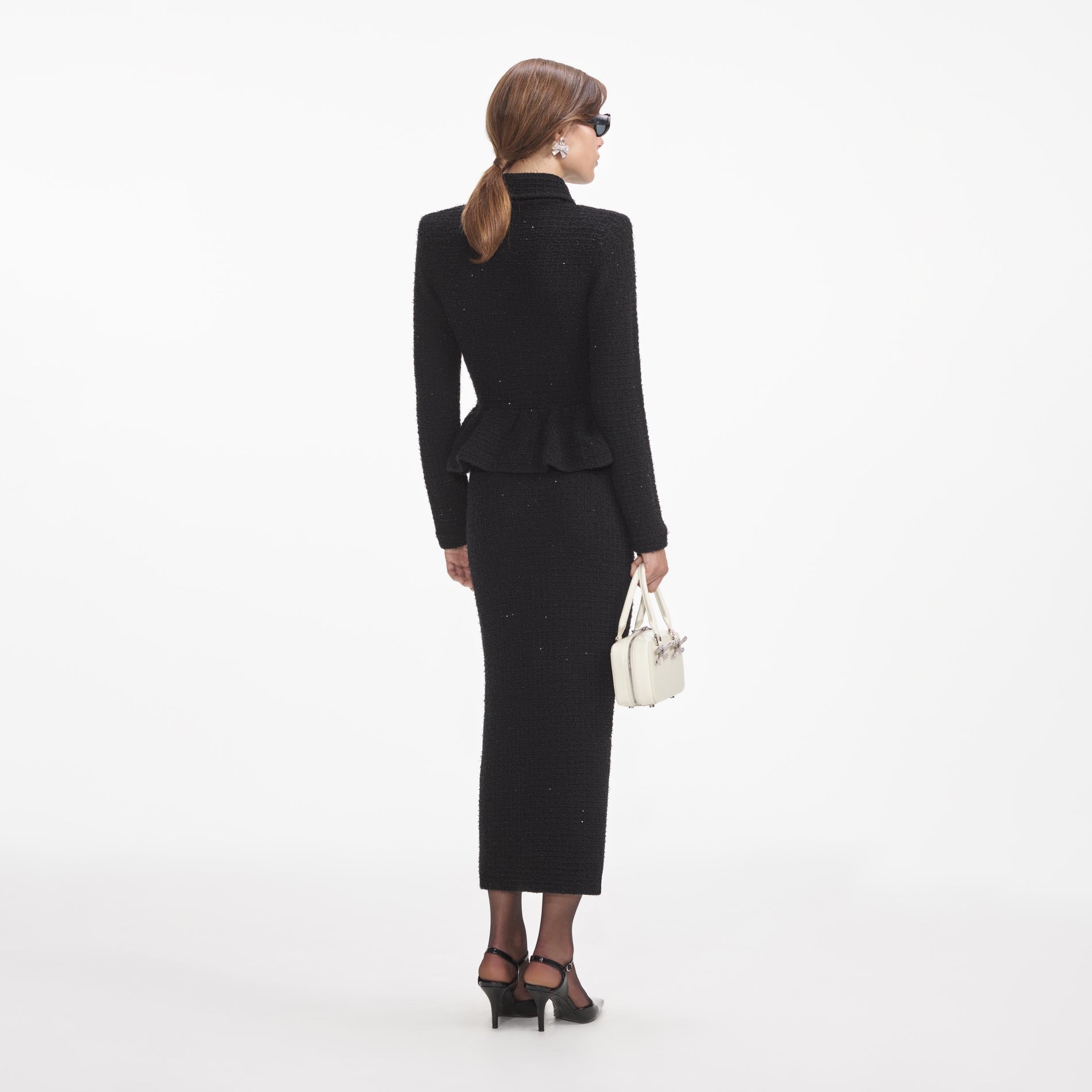 Back view of a woman wearing the Black Textured Knit Peplum Midi Dress