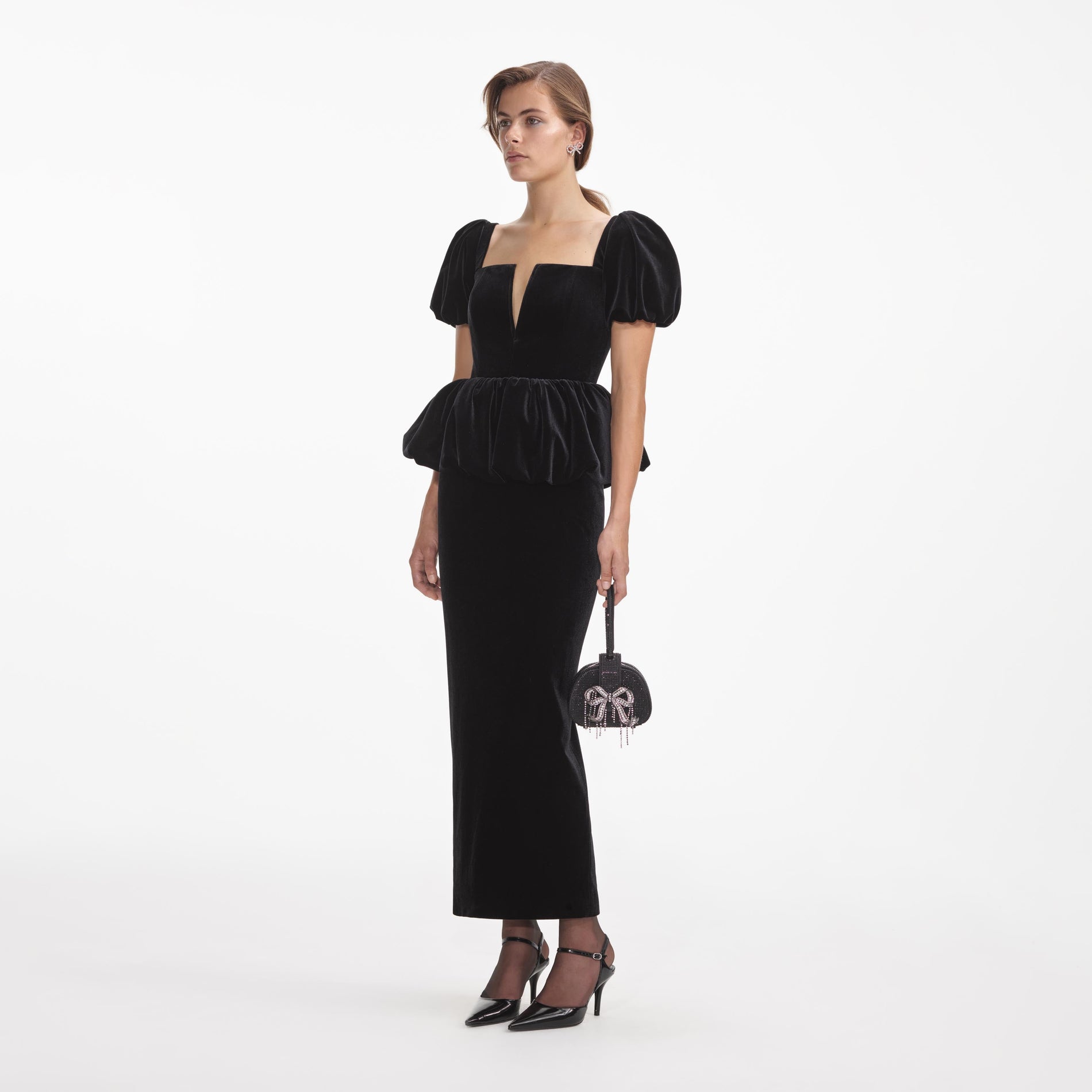 Side view of a woman wearing the Black Velvet Peplum Midi Dress