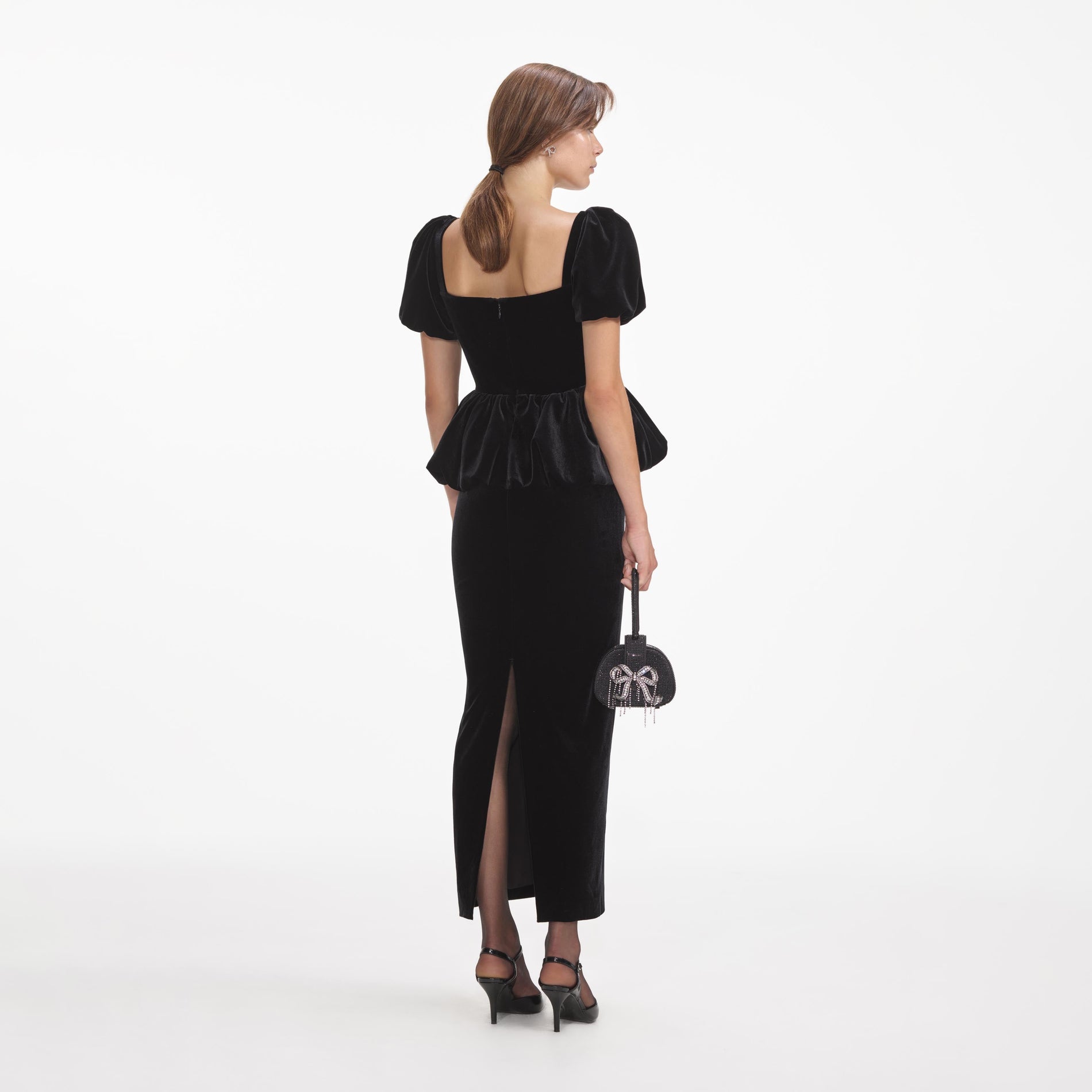 Back view of a woman wearing the Black Velvet Peplum Midi Dress