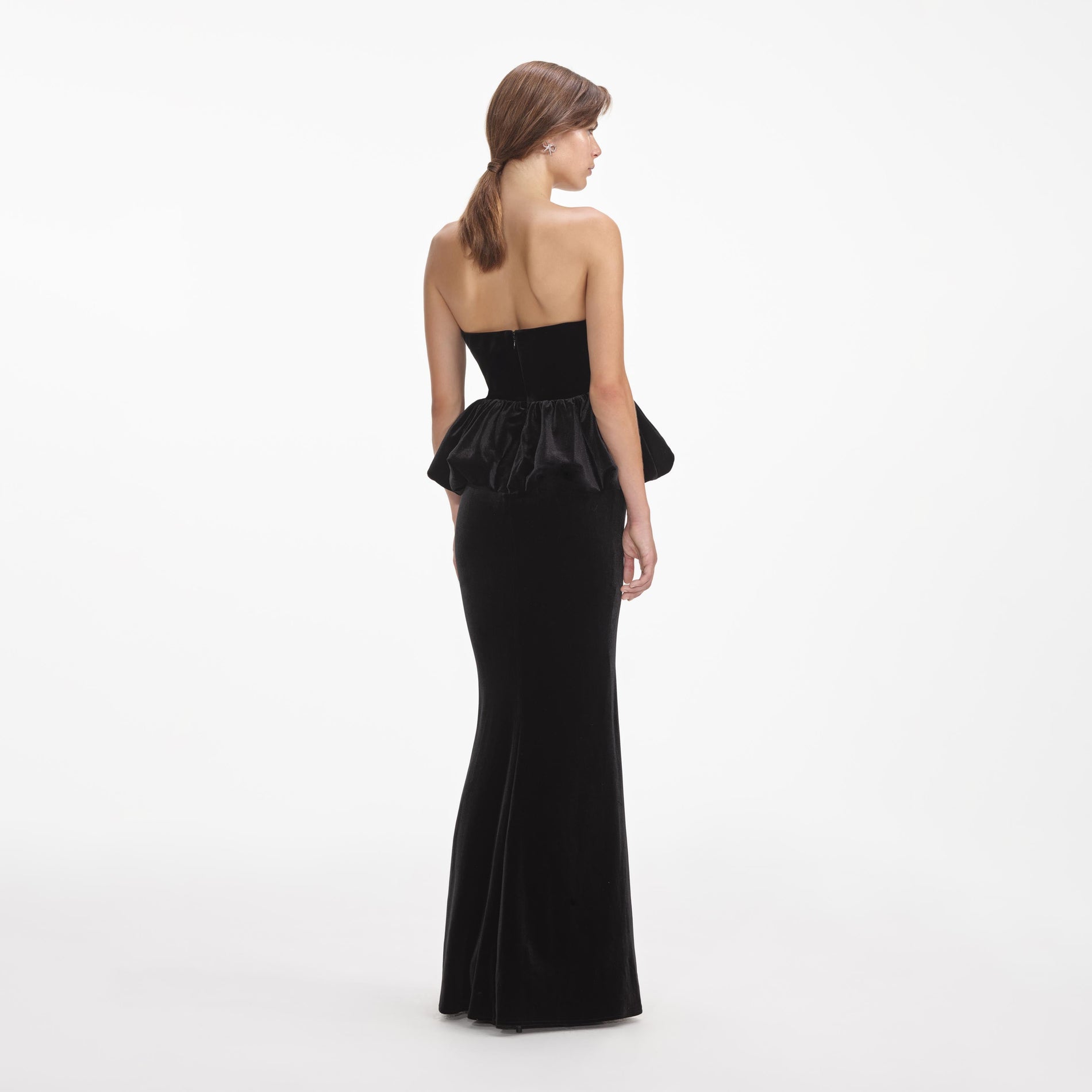 Back view of a woman wearing the Black Velvet Peplum Maxi Dress