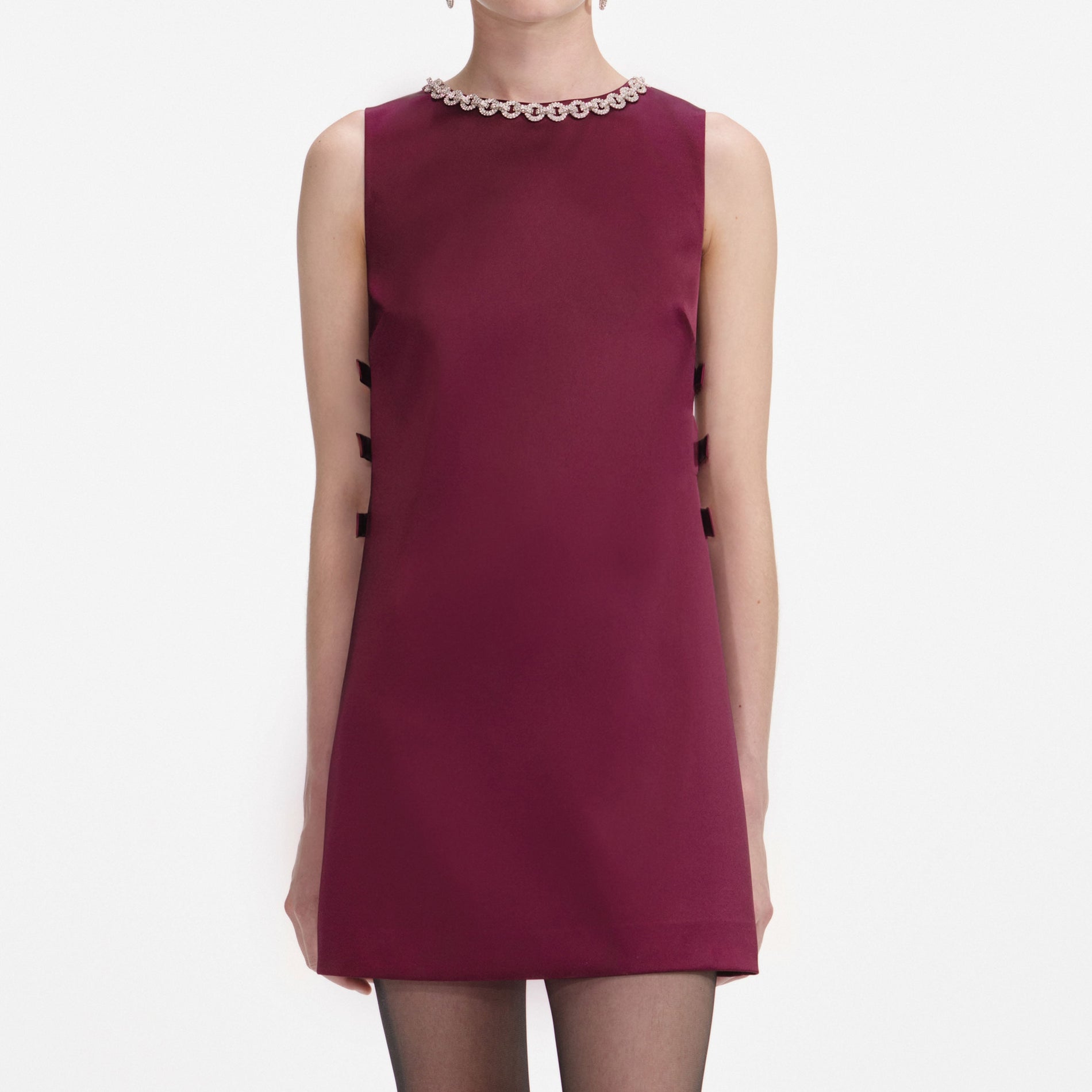 A close up of a woman wearing the Burgundy Satin Cut Out Mini Dress