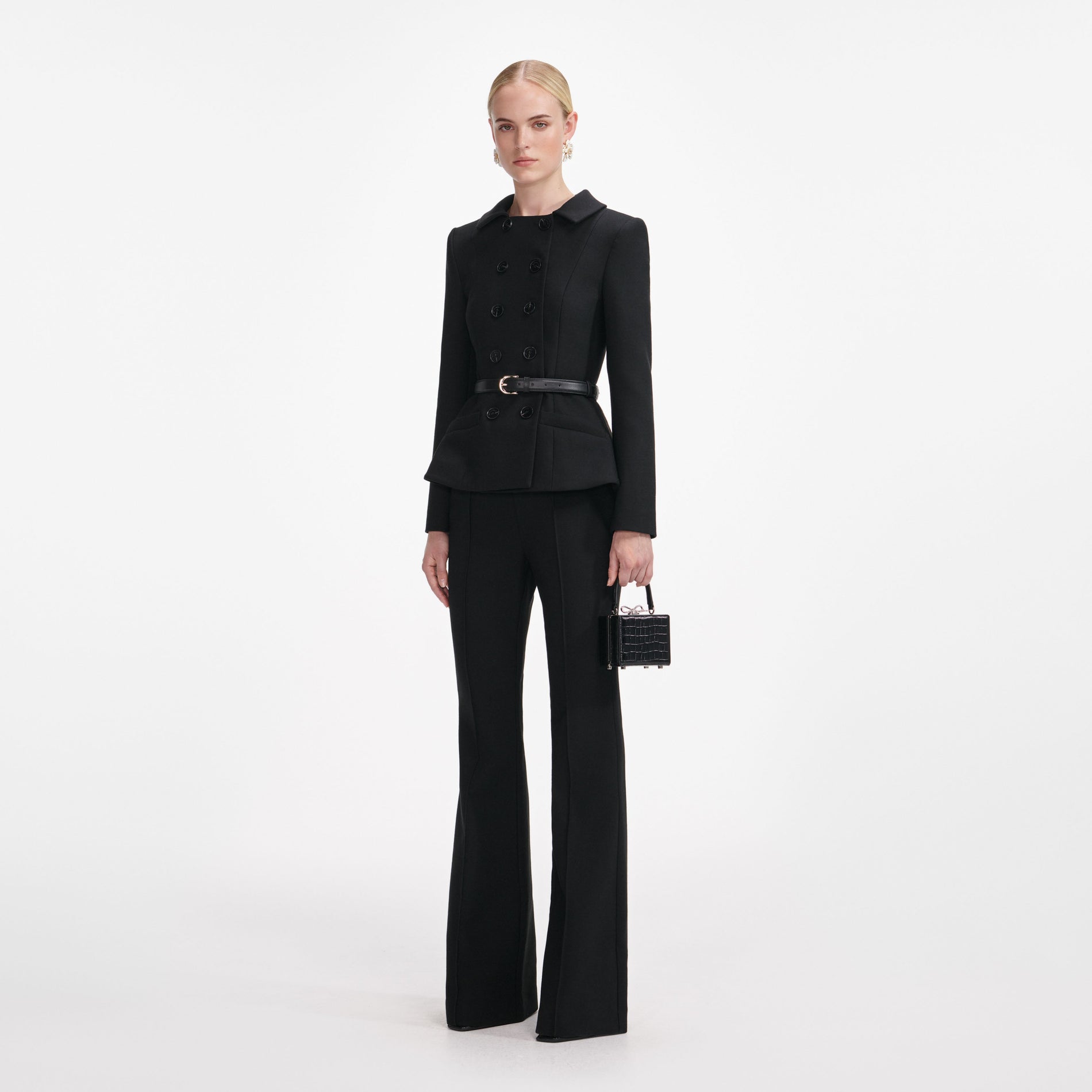 Side view of a woman wearing the Black Wool Double Breasted Jumpsuit