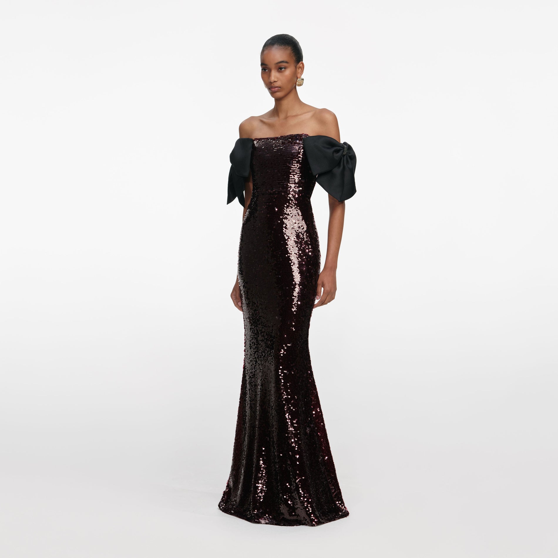 Side view of a woman wearing the Brown Sequin Bow Maxi Dress