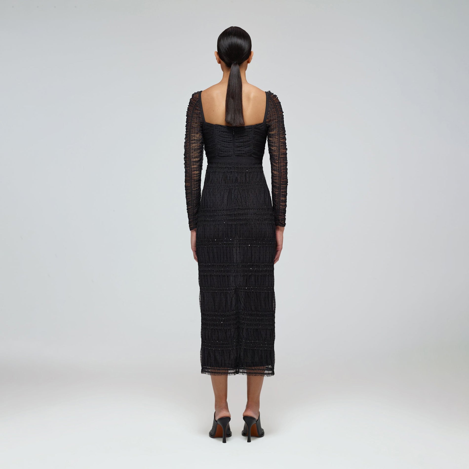 A woman wearing the Black Dot Mesh Shirred Midi Dress