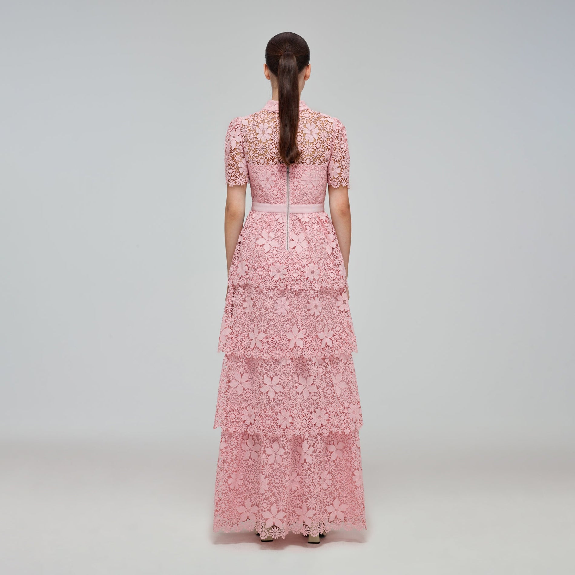 A woman wearing the Pink Tiered Guipure Lace Maxi Dress