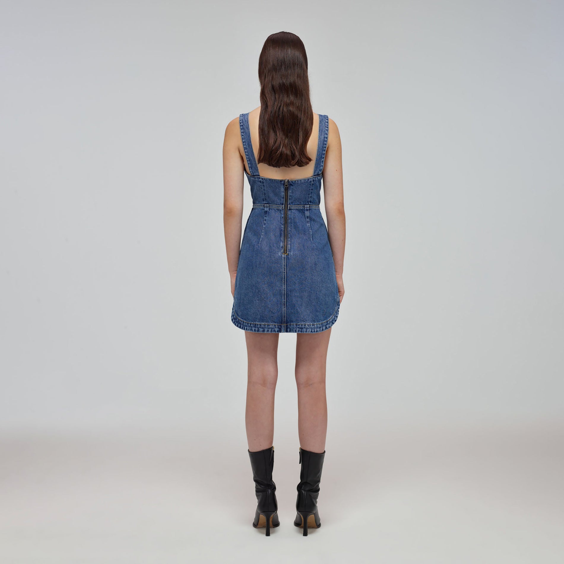 A woman wearing the Blue Denim Bow Mini Dress