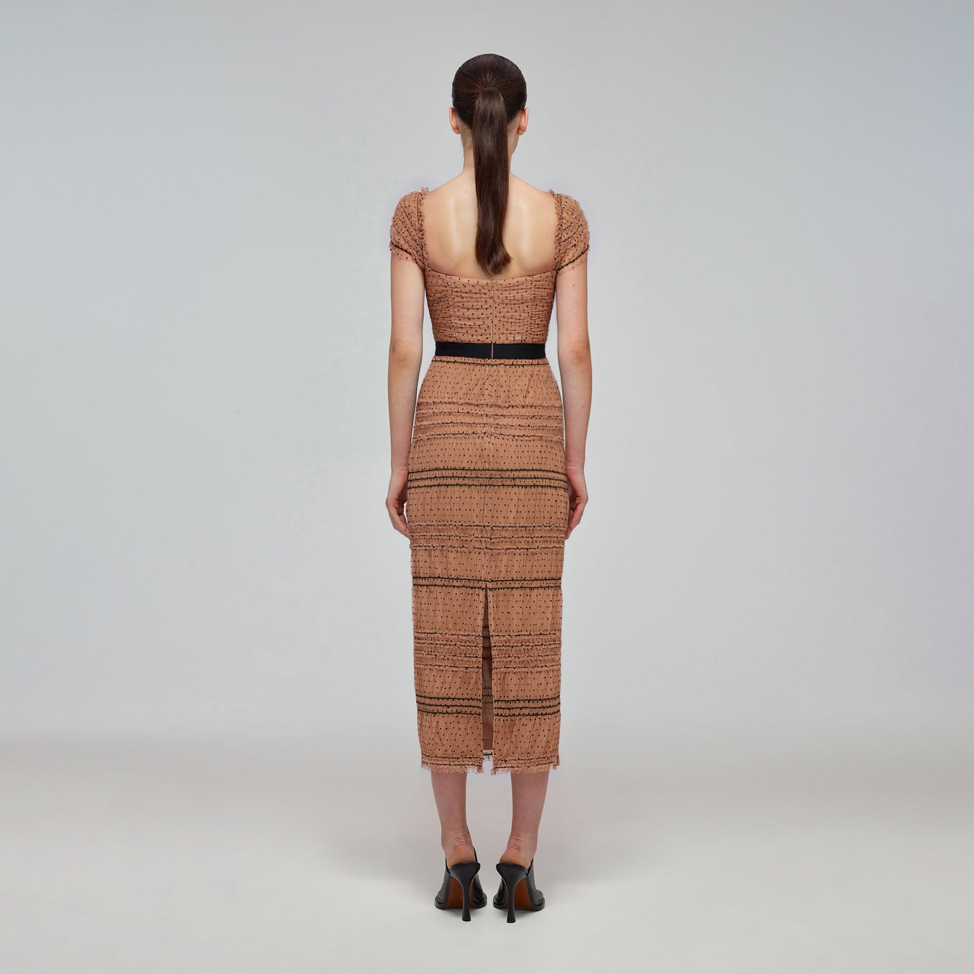 A woman wearing the Tan Dot Mesh Shirred Midi Dress