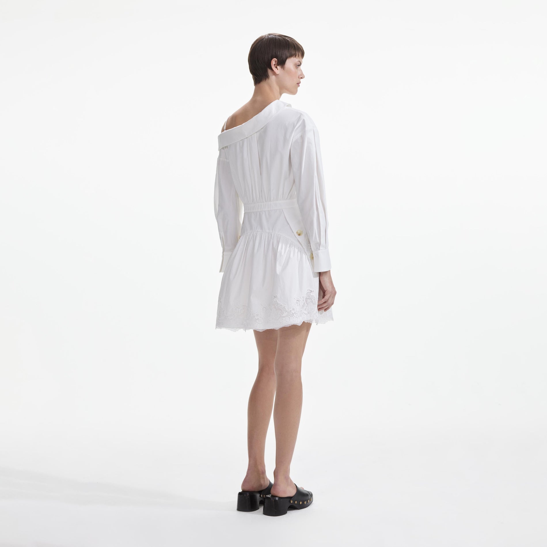 Back view of a woman wearing the White Cotton Lace Hem Mini Dress